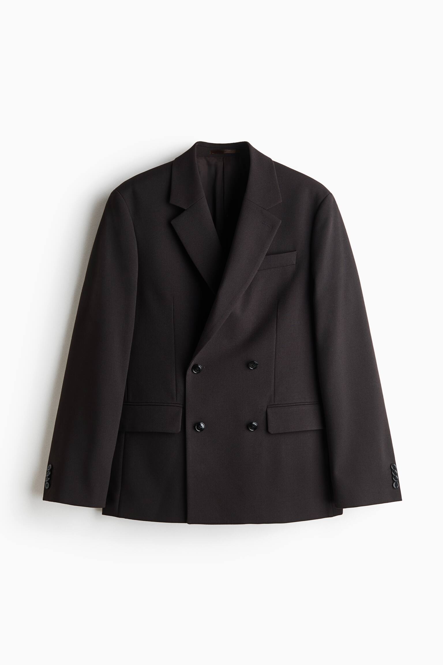 A dark brown double-breasted blazer is shown front-on, featuring sharp notch lapels, a welt pocket on the left chest, and two lower flap pockets. The structured design includes a four-button front fastening and long sleeves finished with buttoned cuffs. - 1