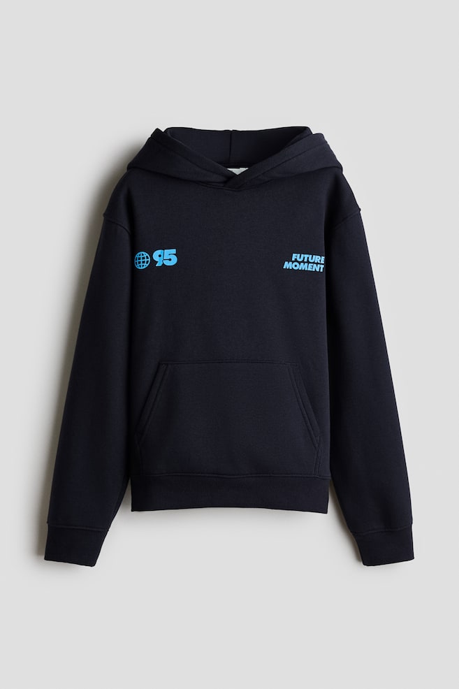 A dark navy blue hoodie is facing front, showcasing a wrap-front lined hood, dropped shoulders, a kangaroo pocket, and ribbed cuffs and hem. The chest is displaying light blue graphic prints, featuring a globe icon with the number "95" on one side and the text "FUTURE MOMENT" on the other. - 1