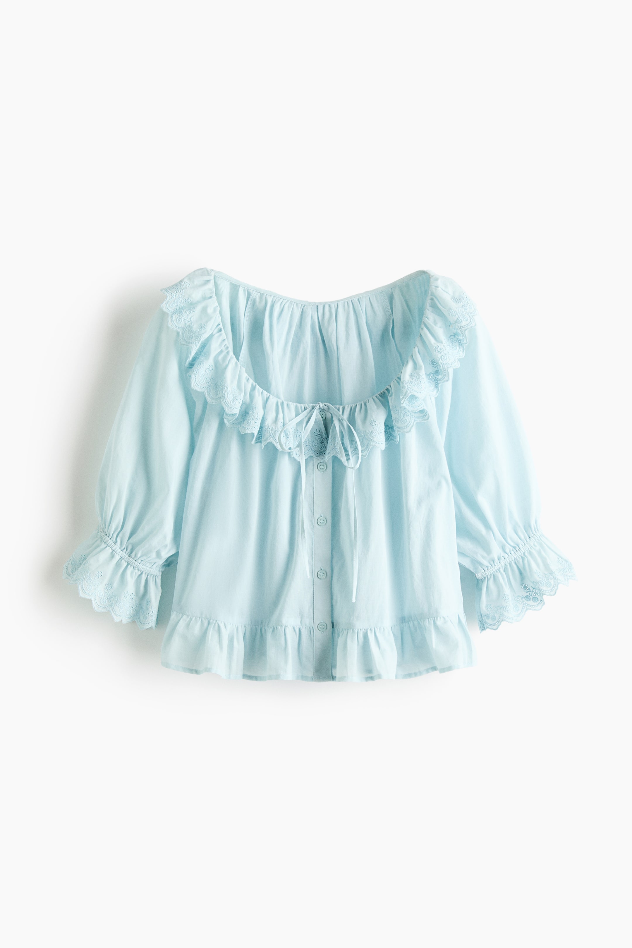 View larger image: The front of a light blue blouse in a cotton weave showcases a deep, round neckline adorned with narrow ties and buttons down the front. It also features elbow-length sleeves with elasticated cuffs, a scalloped flounce with broderie anglaise around the neckline and at the cuffs, a gathered seam at the waist, and a flounced hem.