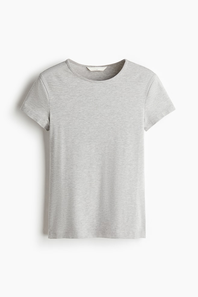Uma T-shirt ajustada em cinzento-claro, em malha jersey de algodÃ£o mesclado, estÃ¡ pendurada de frente, apresentando decote redondo, mangas curtas e bainha de corte reto. - 1