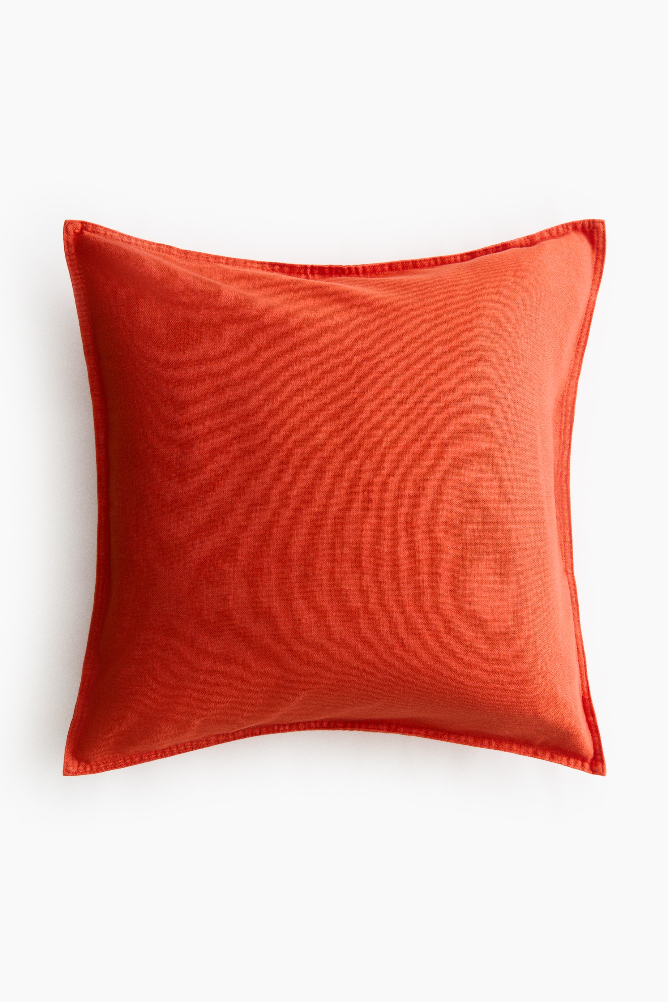 拡大画像を表示: クッションカバーはFRONT(前面)ビューを提示しており、赤みのあるオレンジの正方形で、はっきりした織り目と縁に沿ったステッチが見えます。