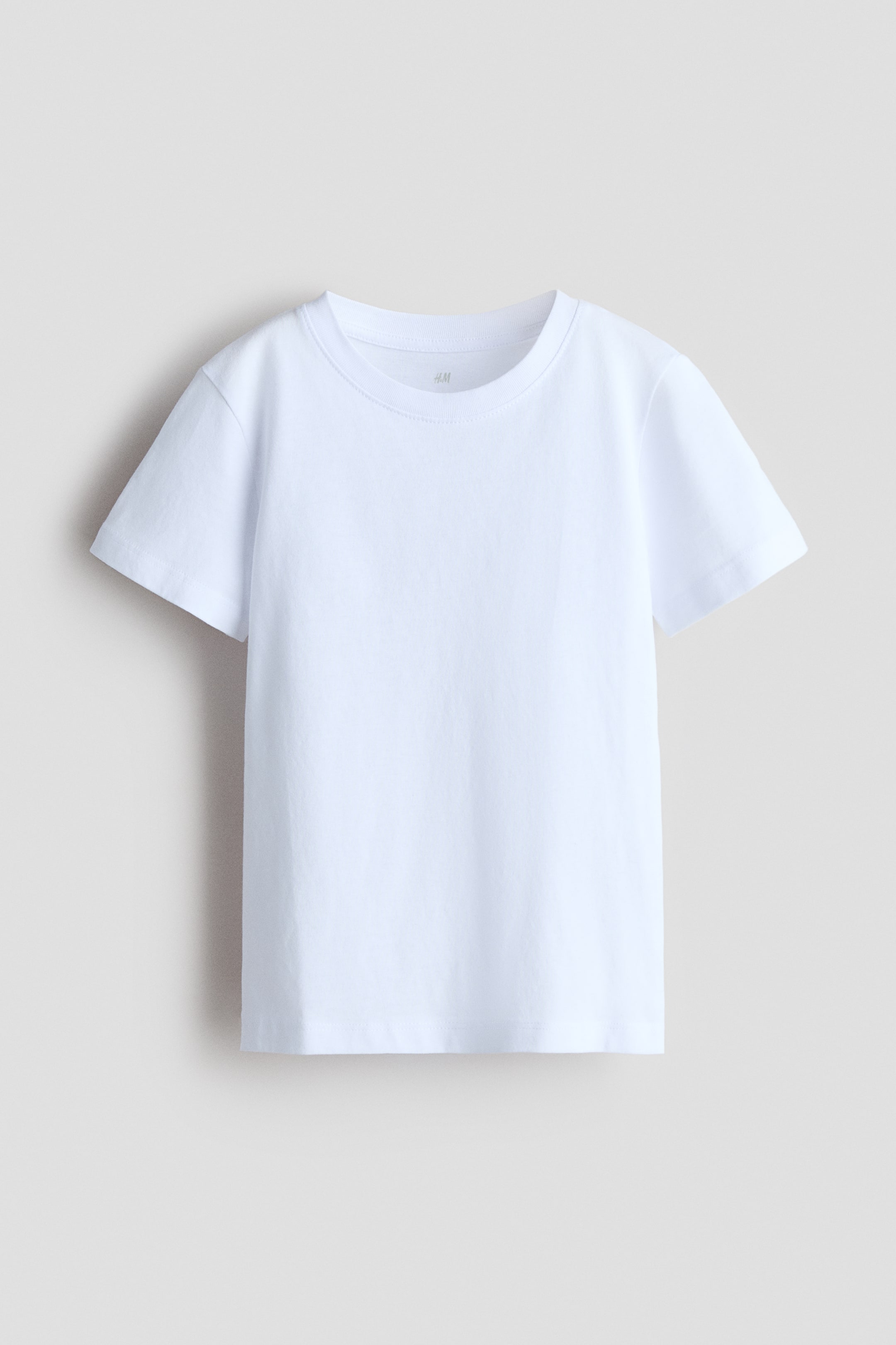 View larger image: A white T-shirt in soft cotton jersey is shown front-facing, featuring a round neckline with ribbed trim, short sleeves, and a straight hem.
