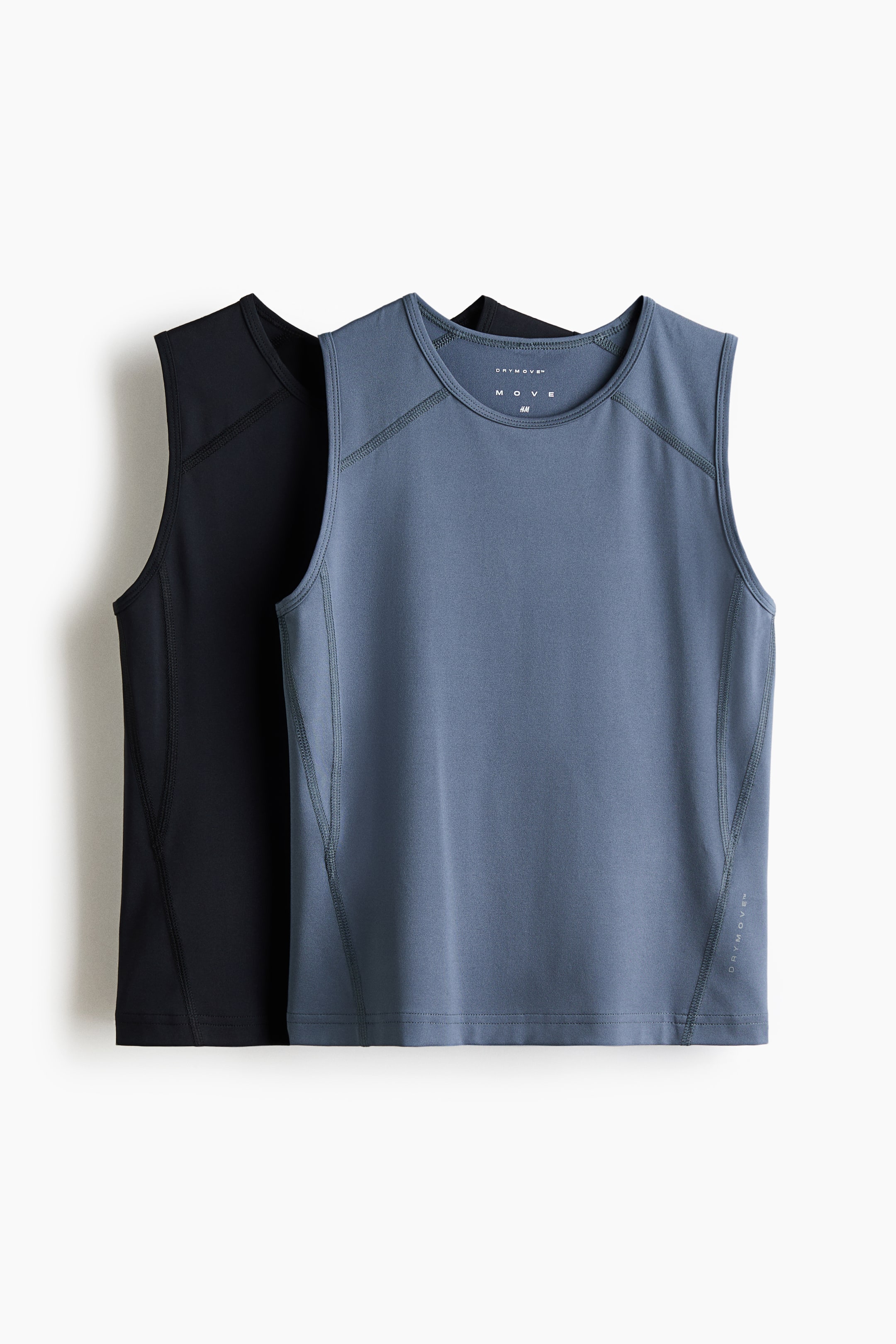 Ver imagen más grande: Dos camisetas sin mangas están superpuestas, con una camiseta azul polvo colocada delante de una camiseta negra, ambas mirando al frente. Presentan escotes redondos y costuras planas visibles a lo largo de los hombros, las costuras laterales y los escotes, con la camiseta azul mostrando la marca "DRYMOVE?" en el interior del cuello y en el lado inferior derecho.