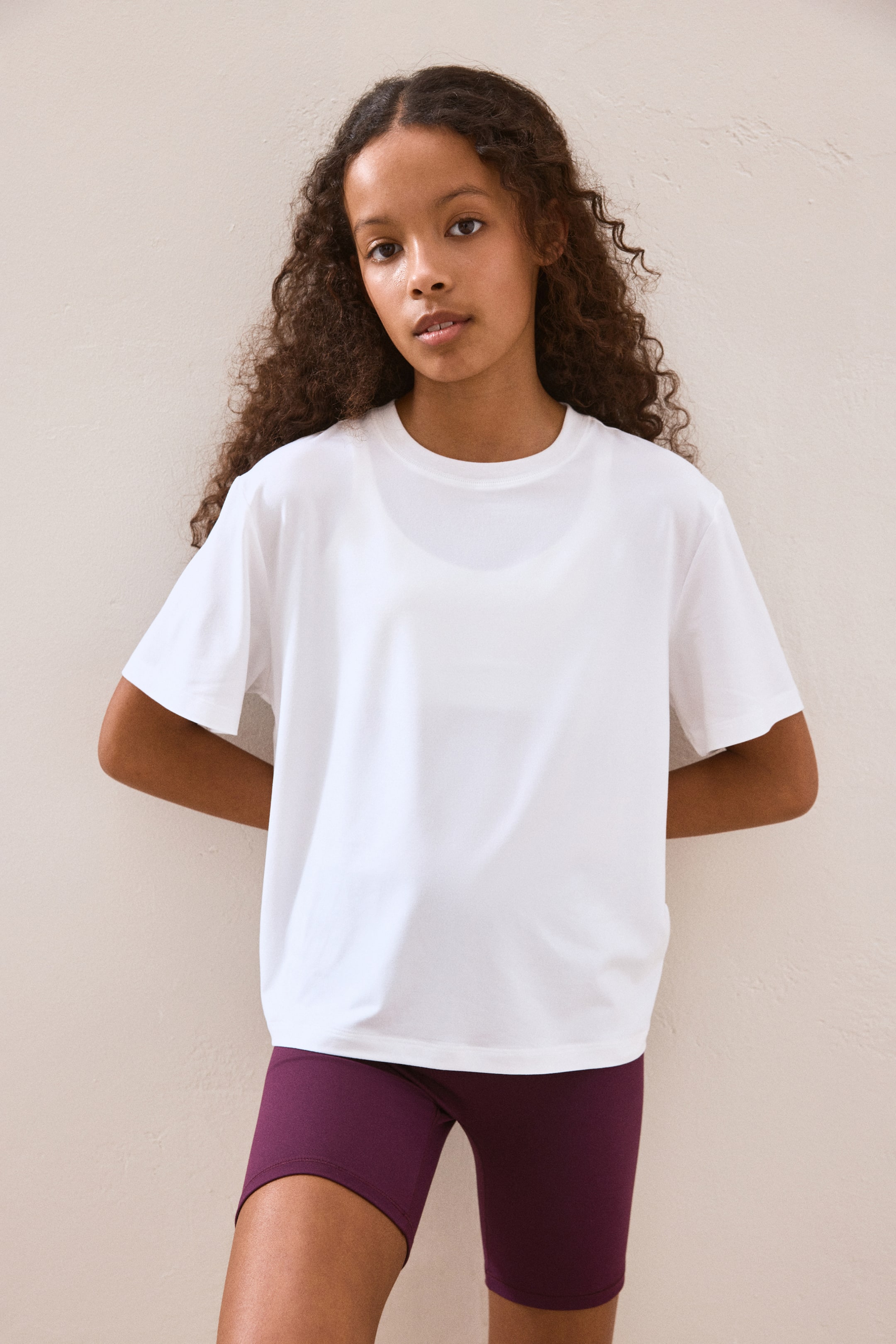 Größeres Bild ansehen: Das weiße T-Shirt verfügt über einen runden Halsausschnitt und kurze, locker sitzende Ärmel. Der Stoff erscheint leicht transparent, sodass ein helles Unterhemd darunter sichtbar ist. Das T-Shirt präsentiert sich in einer entspannten Passform und ist von vorne zu sehen.