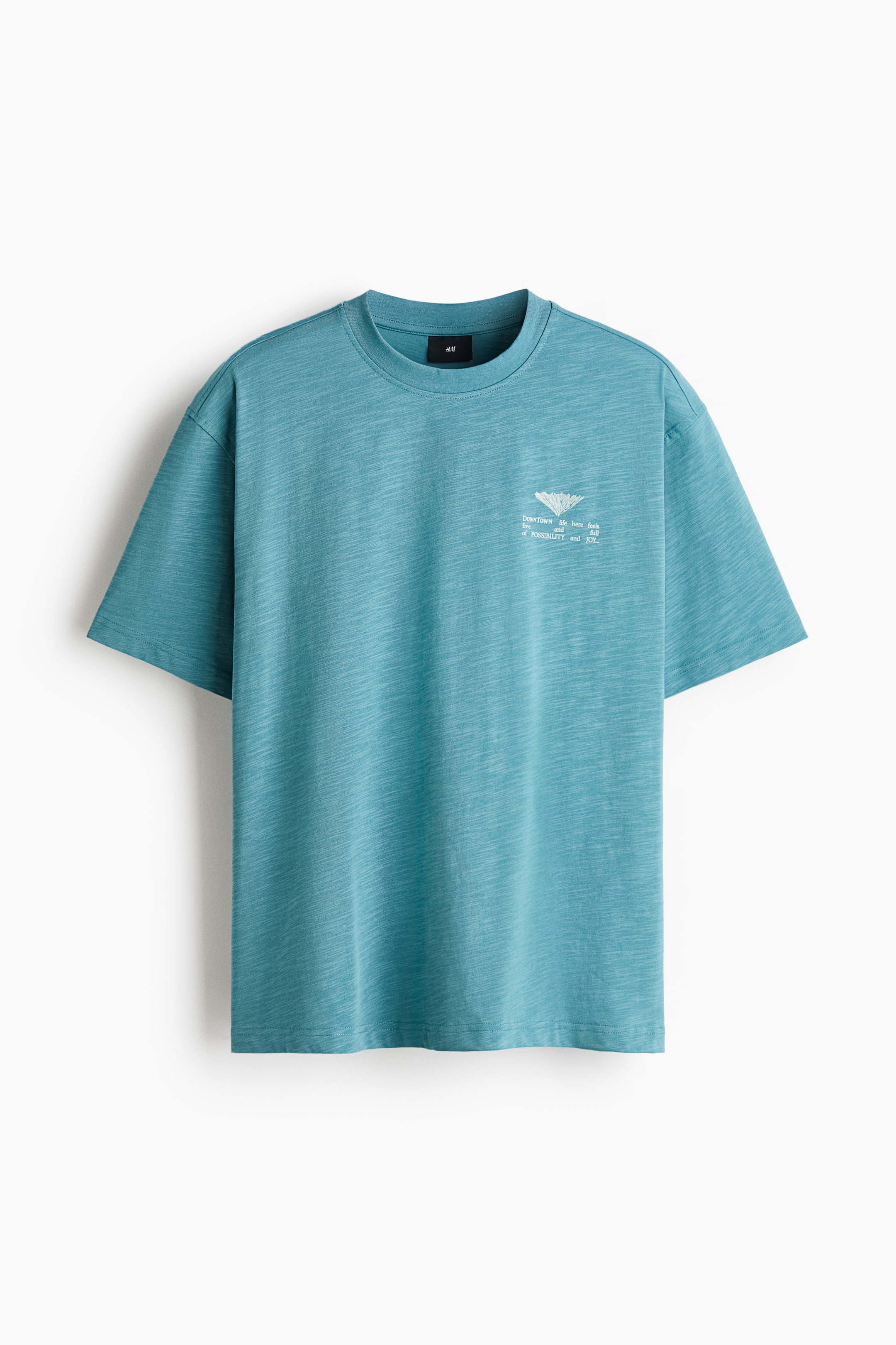 View larger image: A front-facing teal T-shirt in a slub-knit texture shows a relaxed fit, a classic crew neck, and short sleeves. The T-shirt features a small white graphic print with text on the left chest.