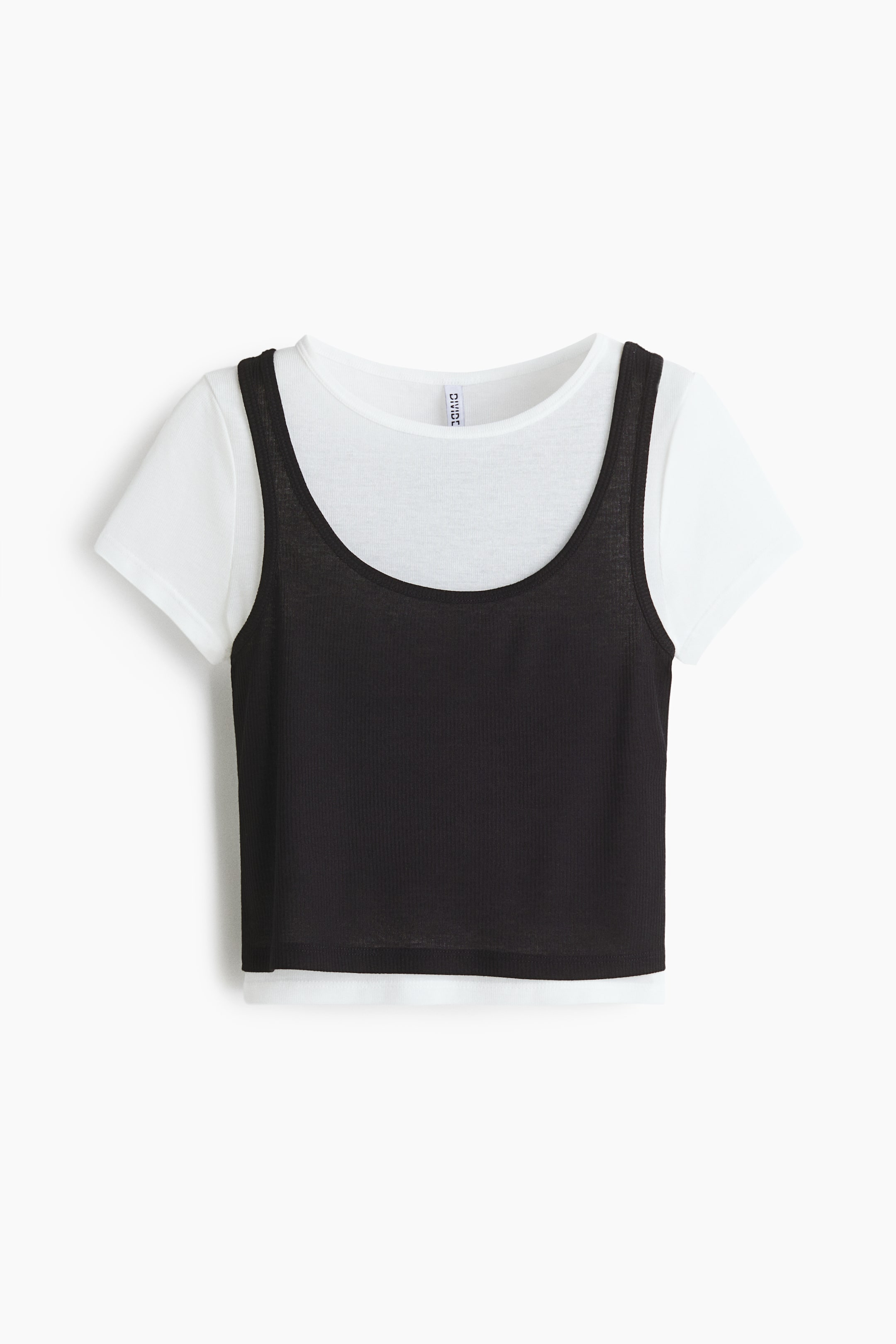 View larger image: A layered top is showcased from the front, featuring a white short-sleeved t-shirt beneath a black ribbed scoop-neck tank top. The black tank top is cropped, allowing the white t-shirt to extend below its hem.