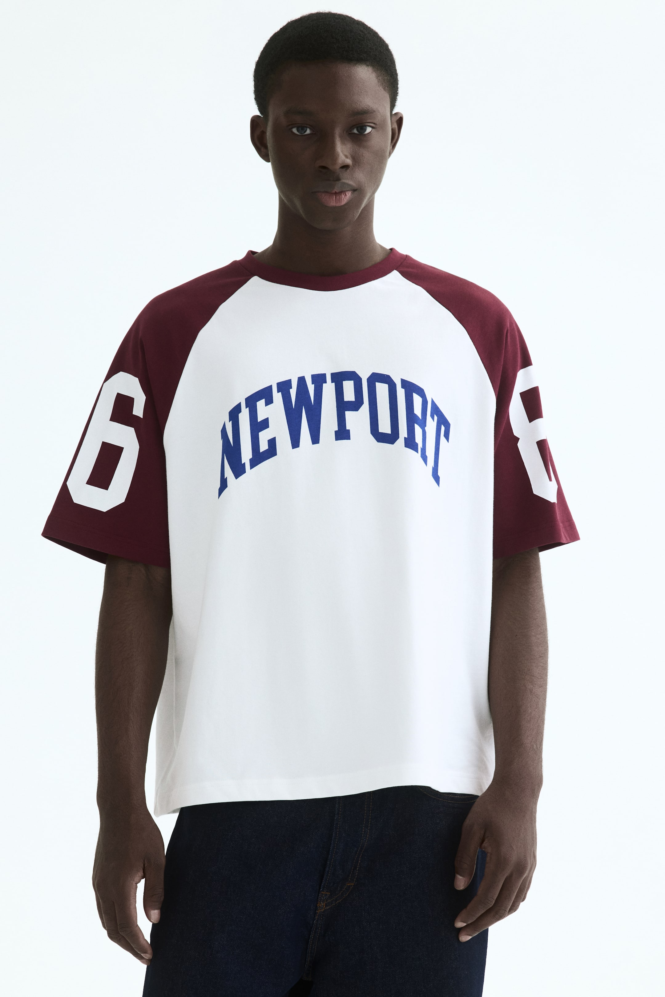 View larger image: The t-shirt showcases a white body with maroon raglan sleeves and a matching round neckline trim. It prominently displays "NEWPORT" in arched blue letters across the chest, with large white numbers "6" and "8" appearing on the left and right sleeves, respectively.