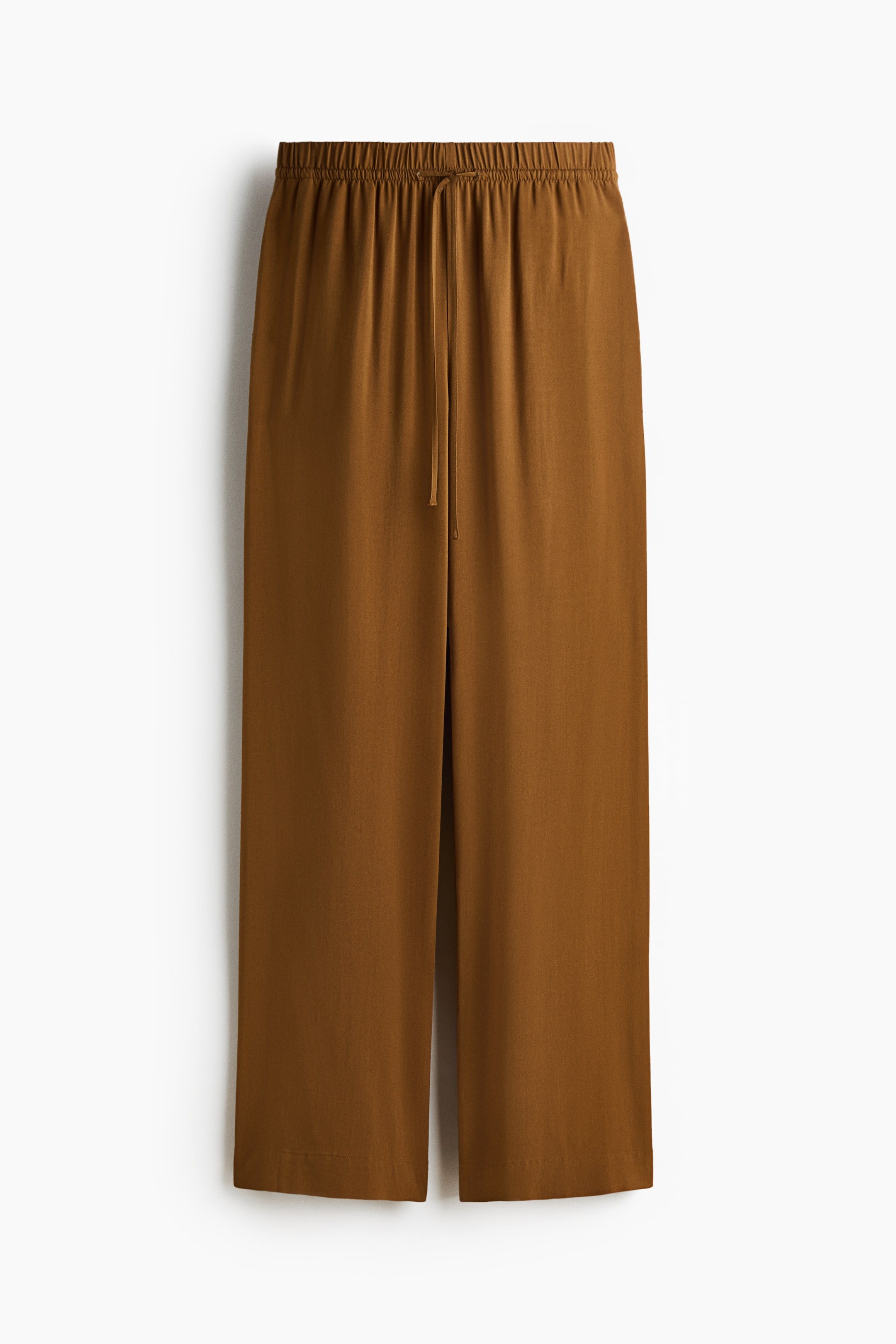 Grotere afbeelding bekijken: Bruine broek in een luchtige viscose weefsel wordt gepresenteerd in een vooraanzicht, met een hoge taille voorzien van bedekte elastiek en een smal trekkoord. Ze tonen een losse pasvorm met wijde, rechte pijpen.