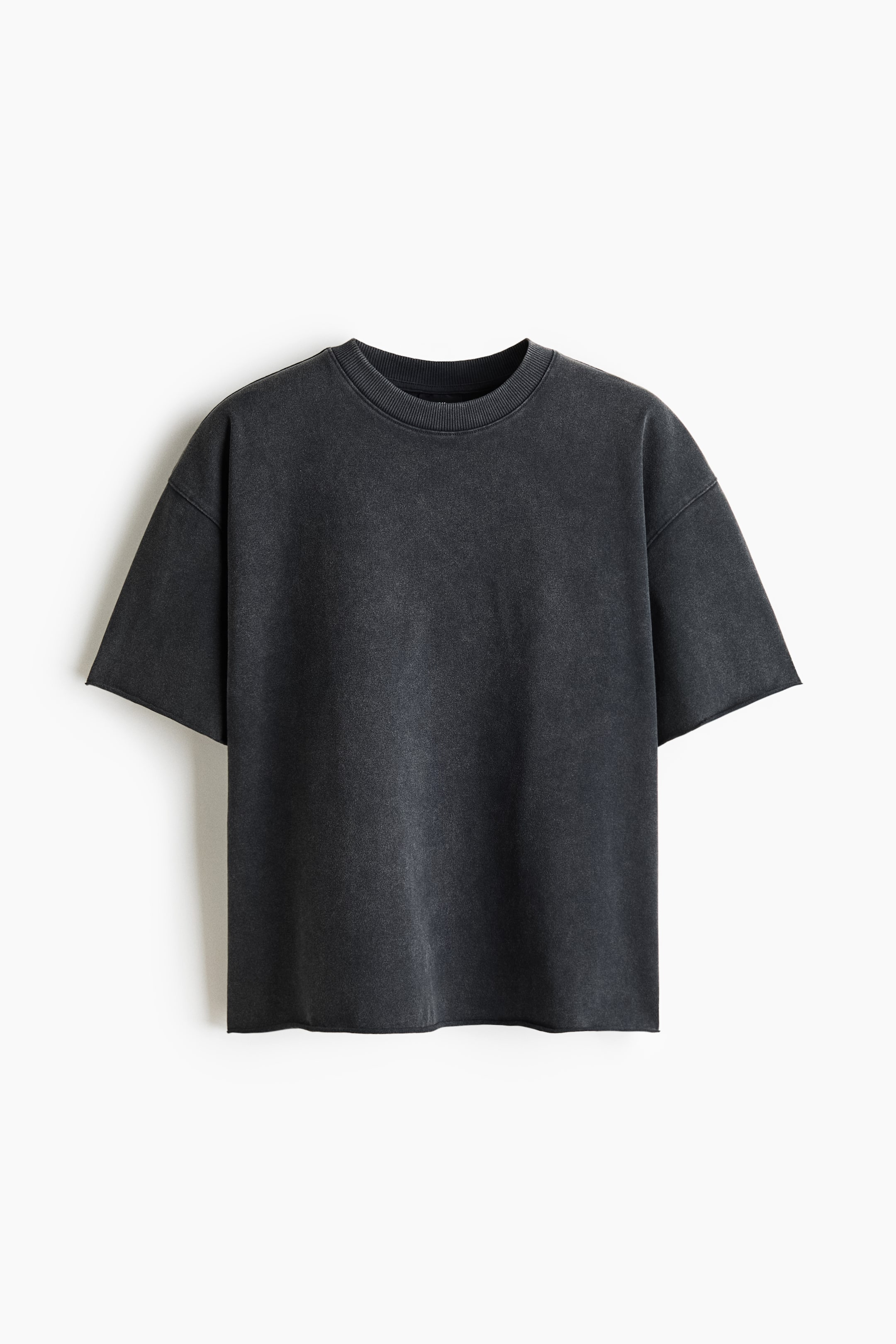 View larger image: A charcoal gray t-shirt is shown from the front, featuring a ribbed crew neck and dropped short sleeves with raw-cut edges. The t-shirt has a faded, distressed look and an unfinished hem.