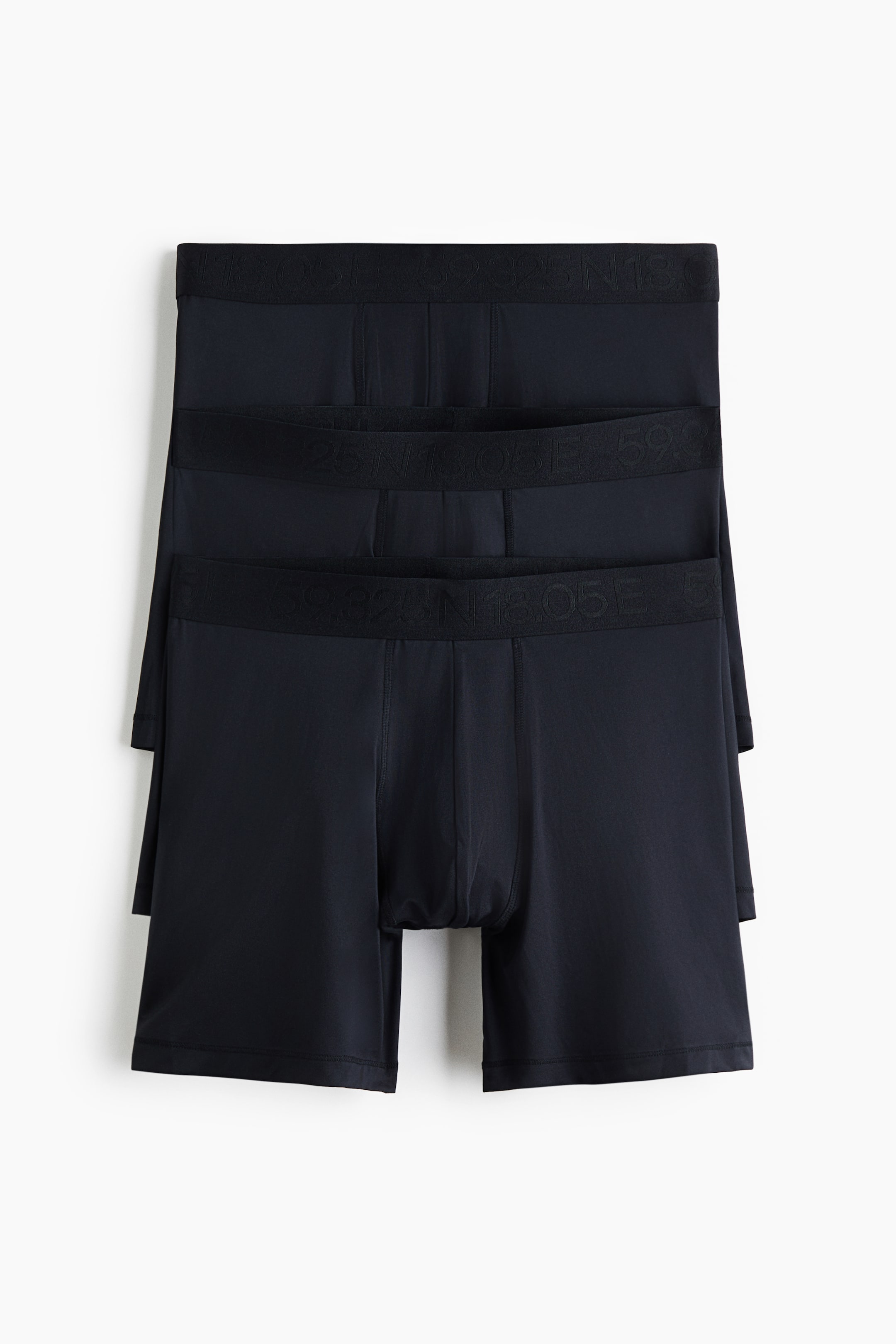 View larger image: Three pairs of black boxer briefs are presented in a vertically stacked layout, facing front, showcasing their smooth fabric and athletic fit. Each pair features a wide, elastic waistband with embossed tonal text and a supportive contoured front pouch.