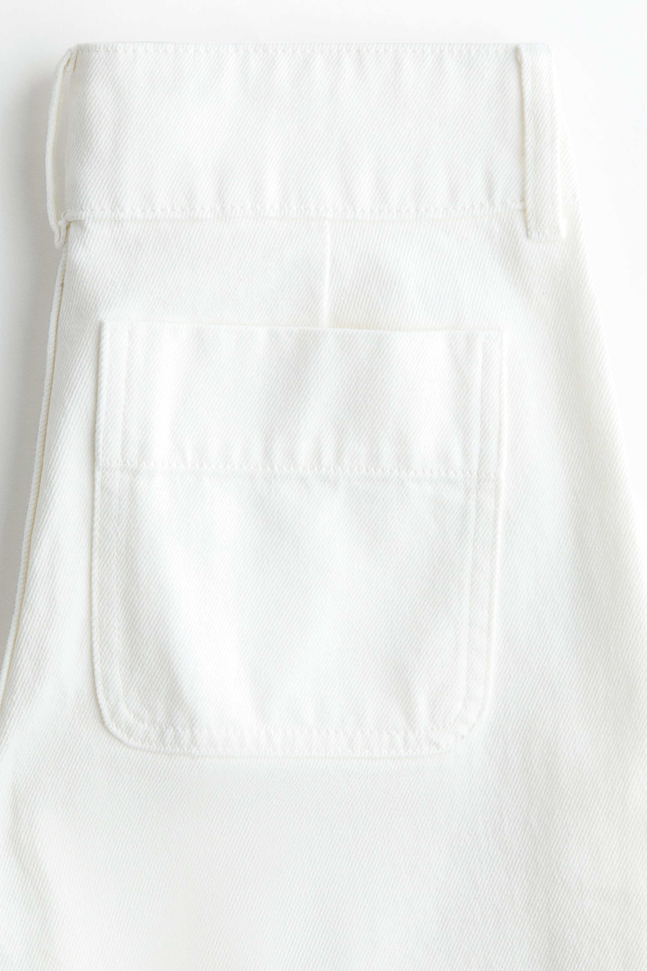 Voir une image plus grande: L'arrière du jean en denim blanc présente une poche plaquée et une ceinture avec des passants pour ceinture.