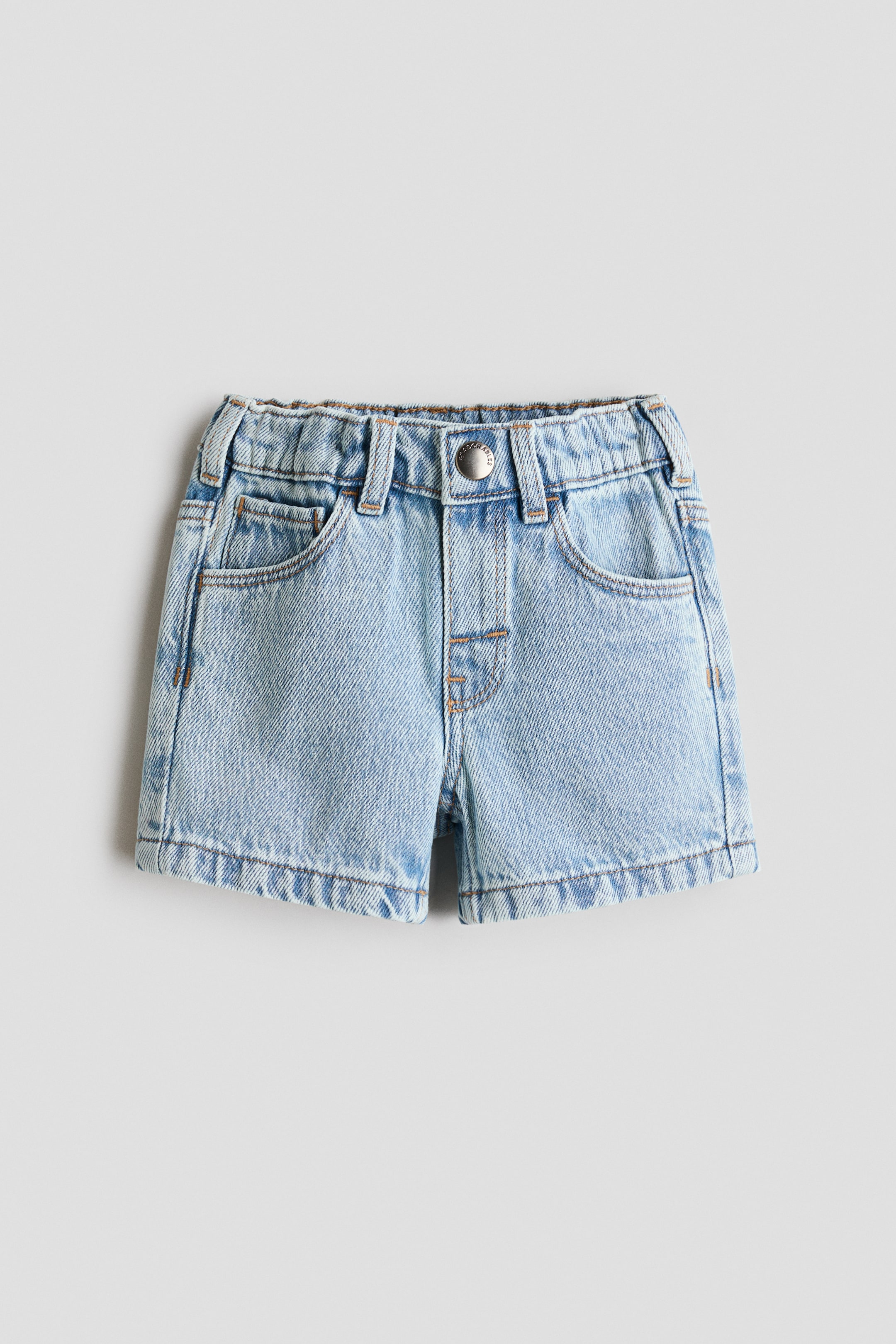 Agrandir l'image: Les shorts en denim bleu clair H&M Adorables sont présentés de face, affichant une coupe à 5 poches. Ils sont dotés d'une taille élastiquée réglable avec fronces visibles, d'une braguette factice et d'un seul bouton-pression.
