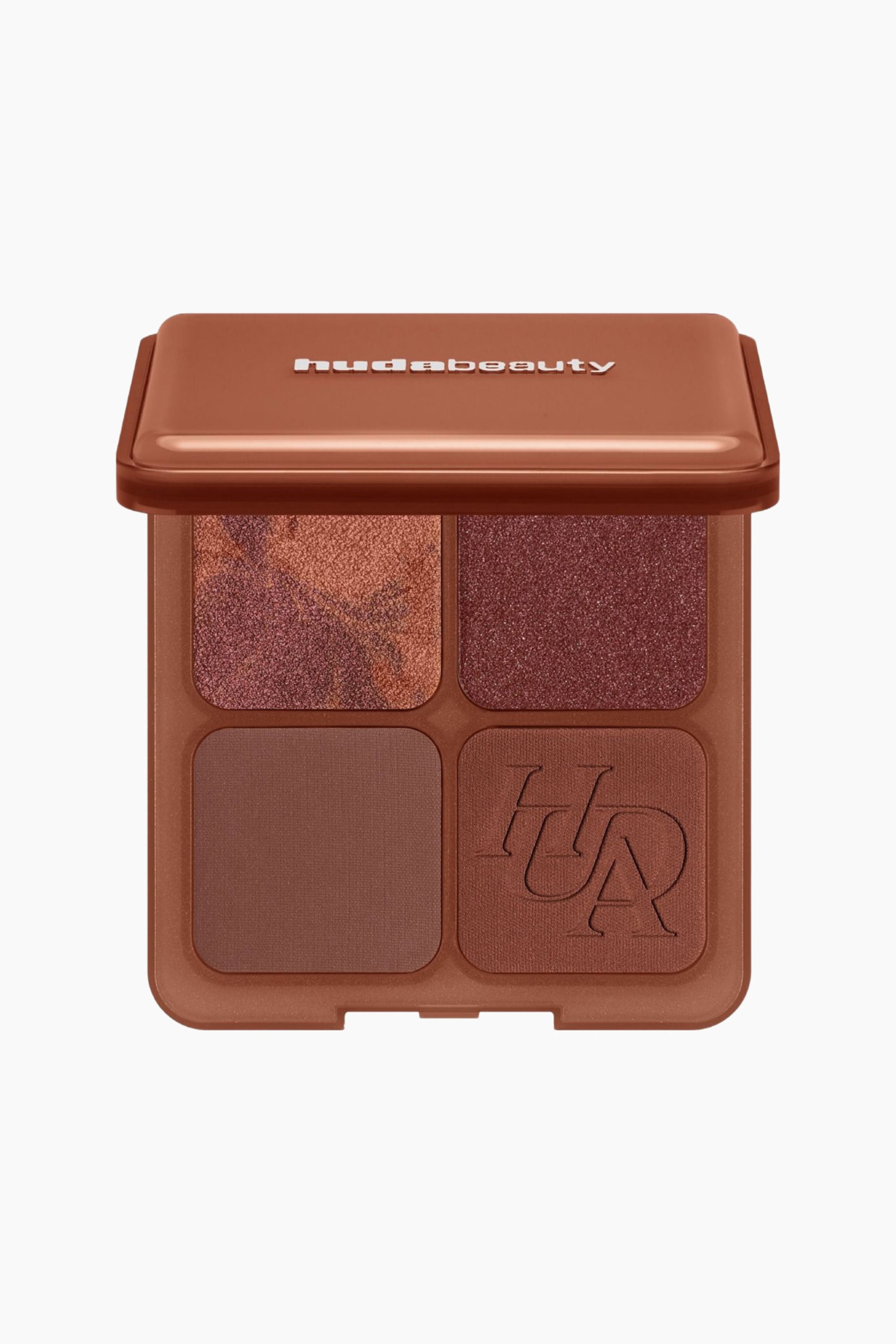 Visa större bild: Bronze Filter Palette står öppen i en framåtriktad vy och visar en fyrkantig brun kompakt med fyra puderpannor. Översta raden visar en marmorerad bronz- och plommonskimrande nyans bredvid en solid djupt plommonskimrande nyans, medan nedersta raden visar en matt mellanmörk brun nyans intill en matt varmbrun nyans präglad med ett stiliserat monogram.