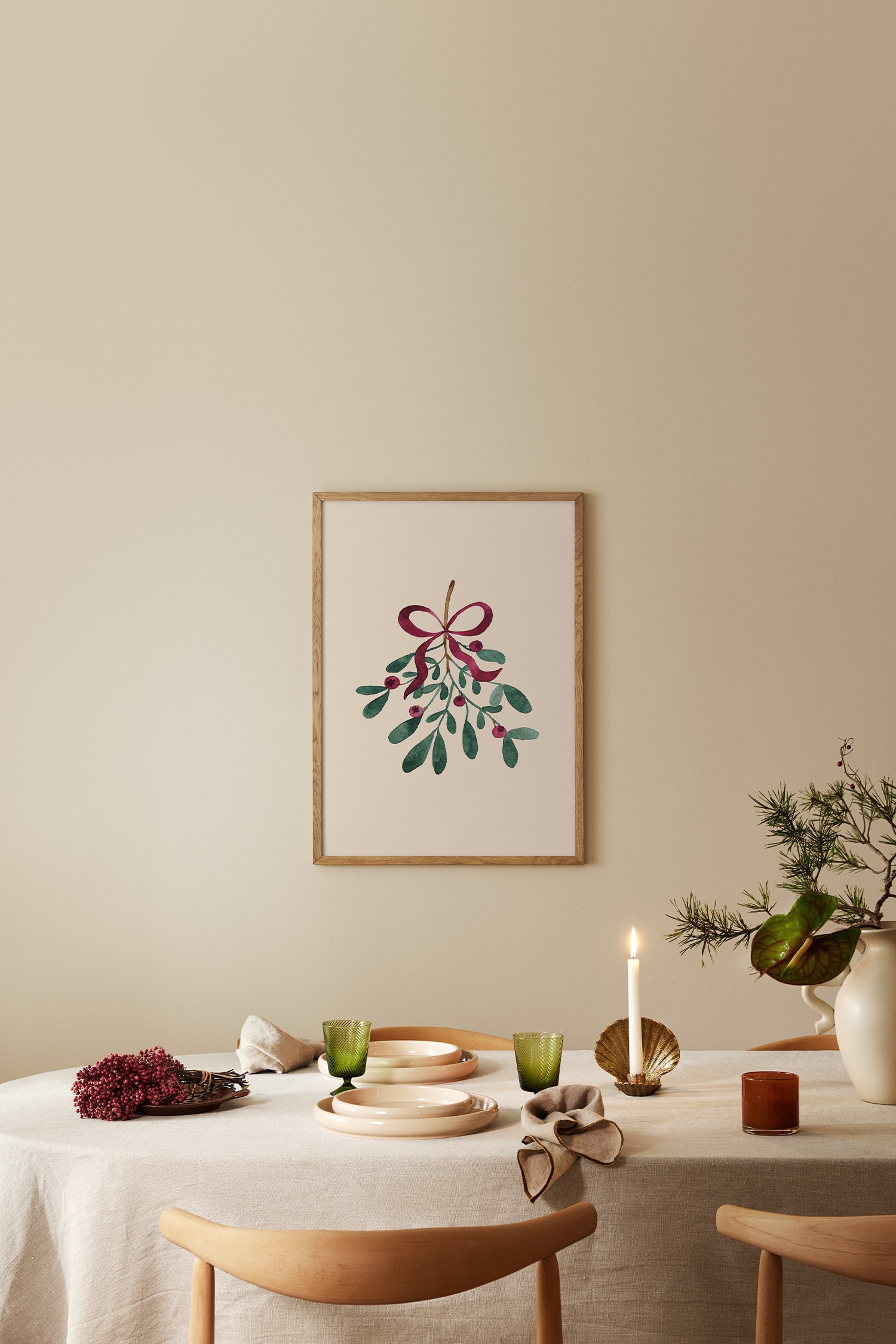 Een verticale kunstprint toont een aquarelillustratie van een hangende maretaktak tegen een crèmekleurige achtergrond. De maretak heeft groene bladeren, kleine rode bessen en een bordeauxrood lint dat bovenaan de steel in een strik is vastgeknoopt.