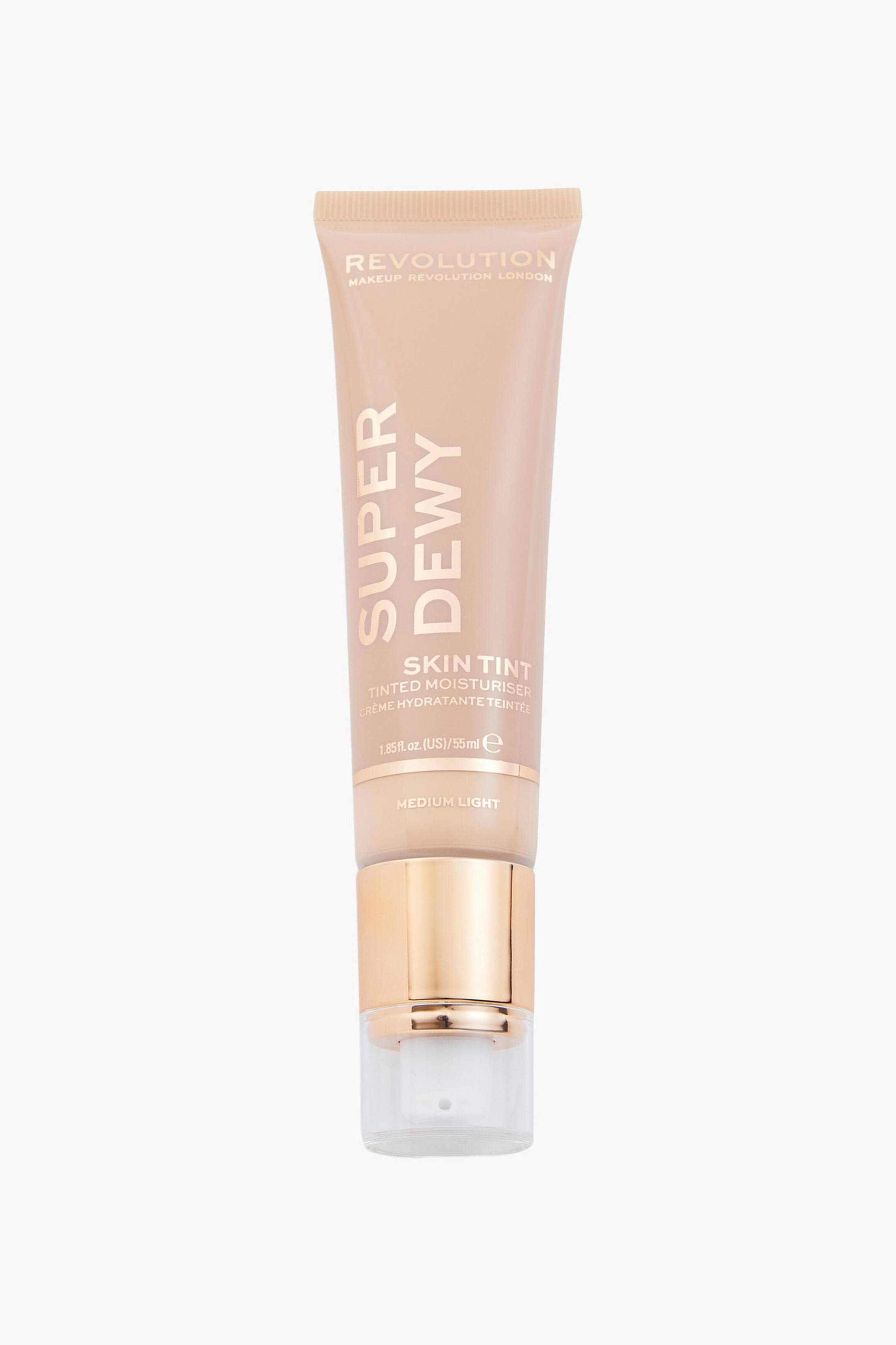 Näytä suurempi kuva: Superdewy Tinted Moisturiser on pystyasennossa ja suunnattu eteenpäin, esitellen beigensävystä puristettavaa tuubia, jossa on valkoinen ja ruusukultainen brändäys. Siinä on metallinhohtoinen ruusukultainen pumppualusta, valkoinen annostelusuutin ja läpinäkyvä suojakorkki.