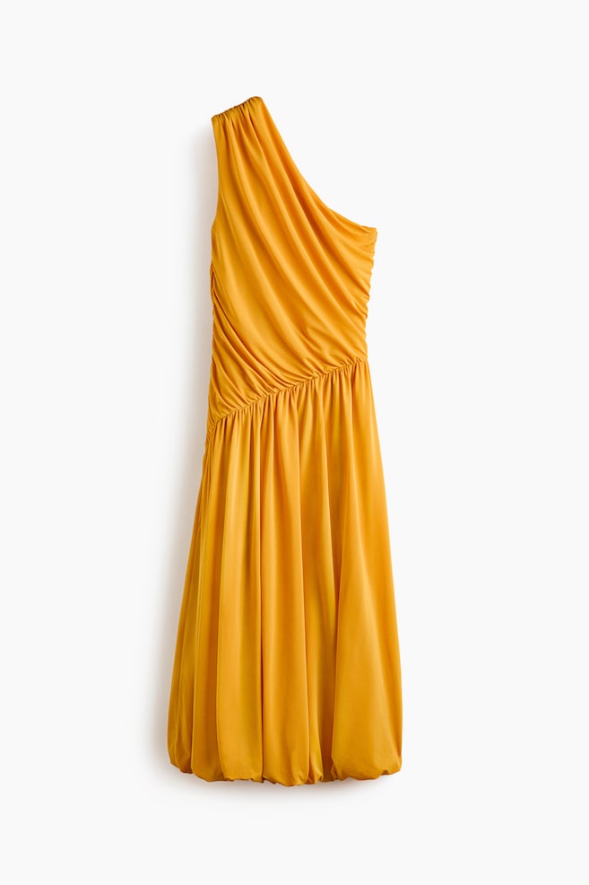 Ein goldgelbes One-Shoulder-Kleid mit gerafftem Ausschnitt, umfangreichen Raffungen über das Oberteil und die Seite sowie einem fließenden Rock, der in einem gerafften Saum endet und eine dezente Blasensilhouette bildet. - 1