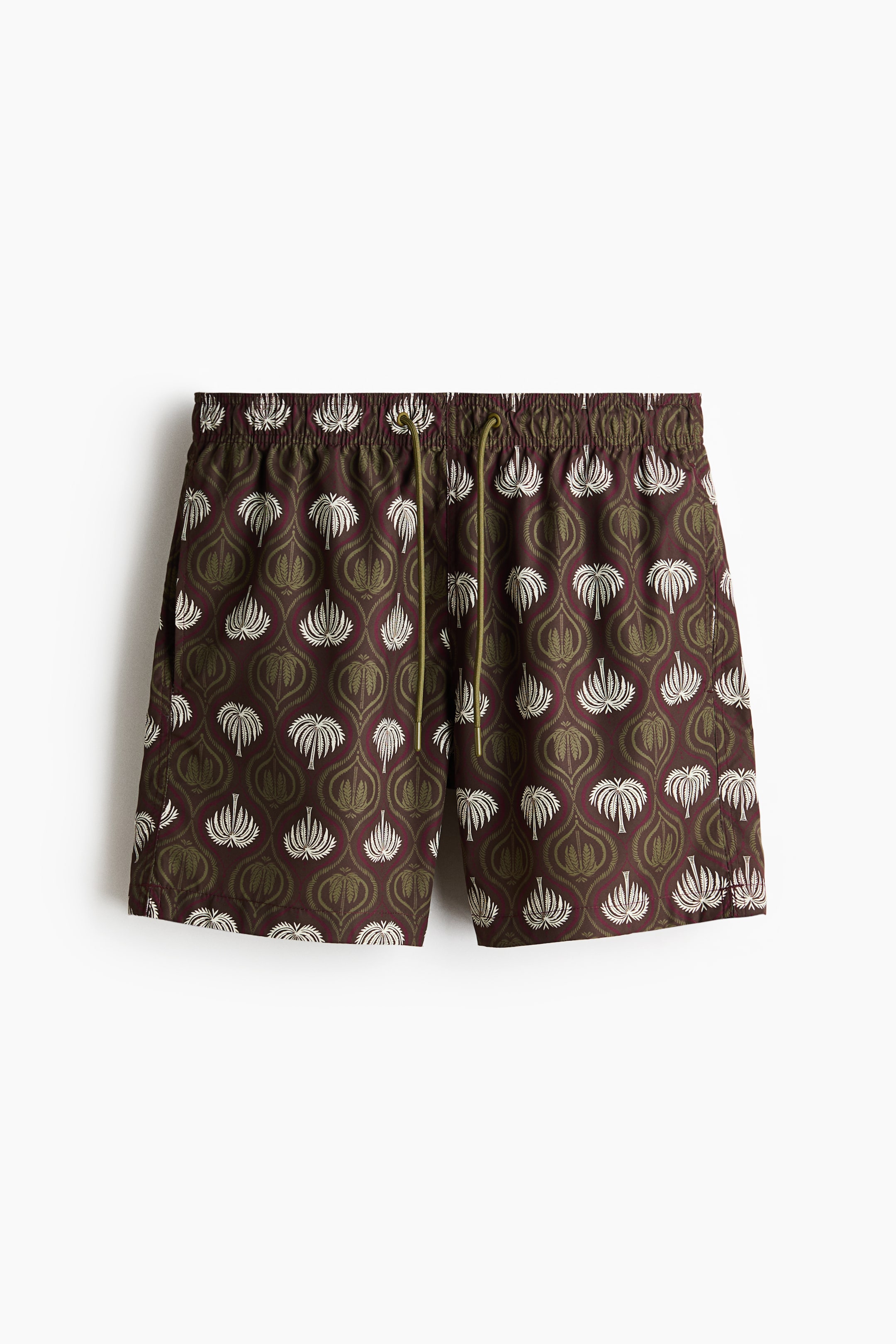 View larger image: Swim shorts are displayed from the front, highlighting a deep maroon hue adorned with an intricate pattern of white and olive green stylized motifs. The shorts feature an elasticated waist with an olive green drawstring, and small slits can be seen at the side of the hems.