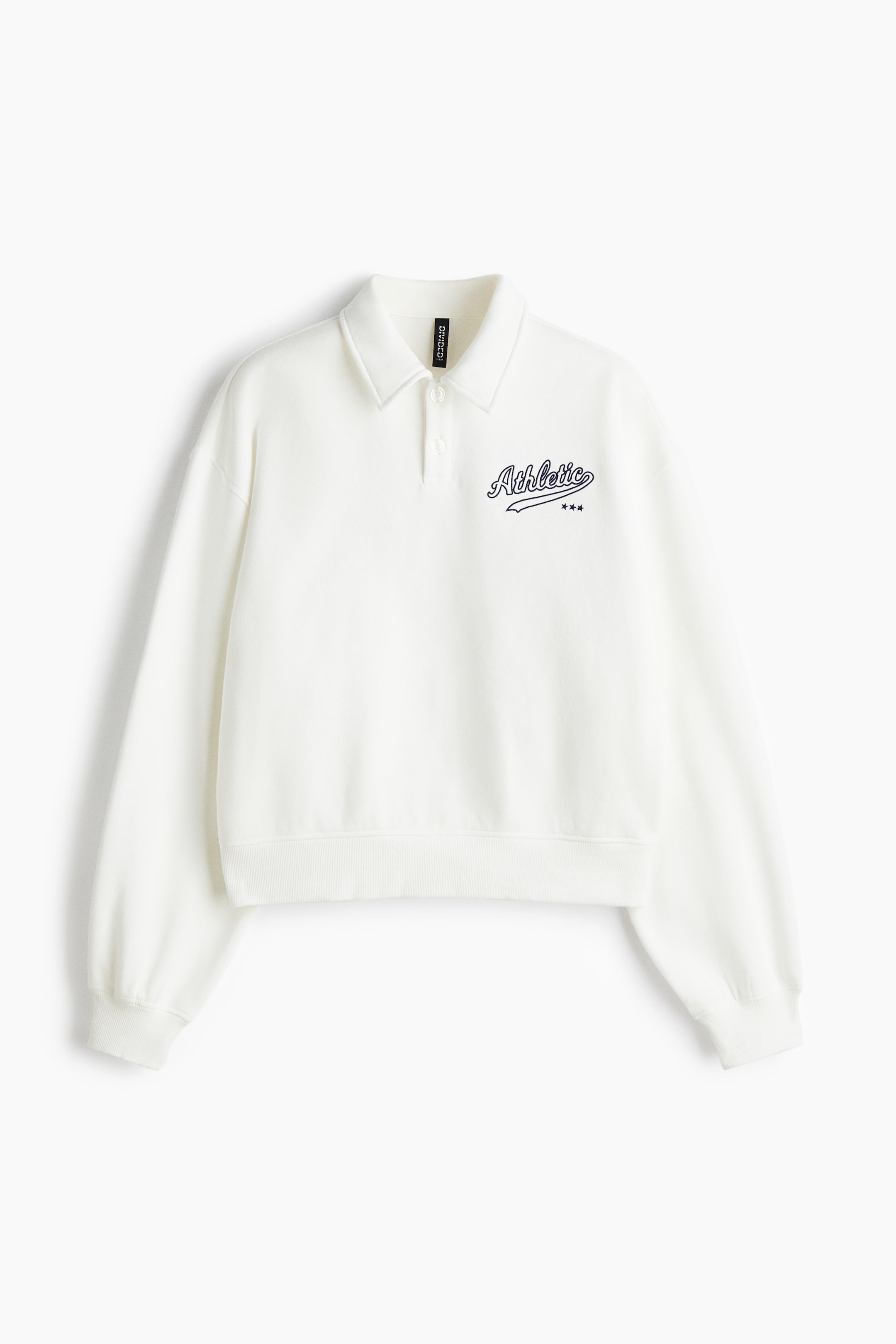 View larger image: A cream-colored long-sleeved polo sweatshirt is being presented from the FRONT. It is featuring a two-button placket and a classic polo collar. A black "Athletic" script graphic with three stars is adorning the left chest, and the sweatshirt is showcasing dropped shoulders, ribbed cuffs, and a ribbed cropped hem.