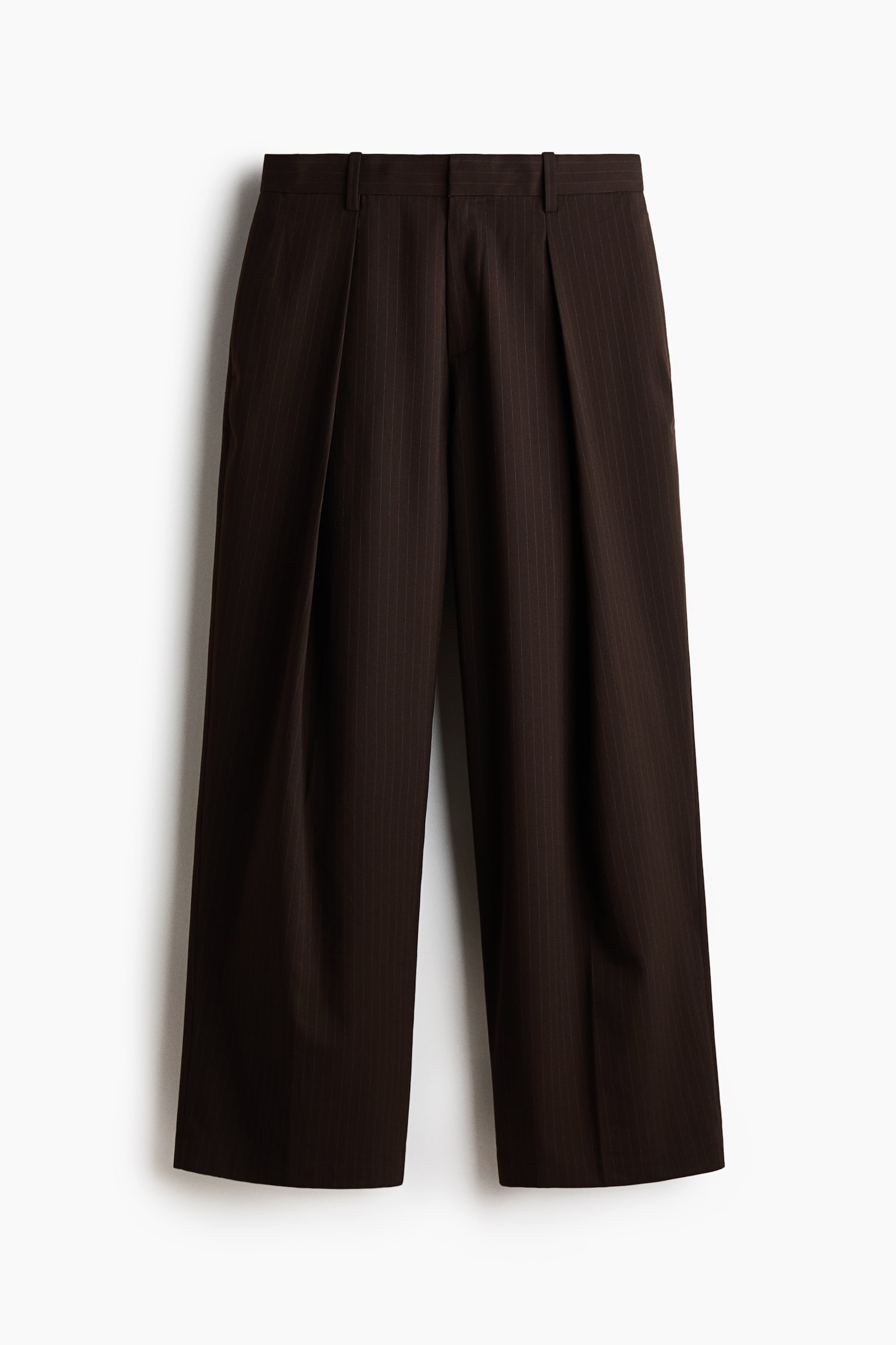 Dark brown pinstriped pants tergantung rata dan menghadap ke depan. Ia menampilkan potongan kaki lebar dengan lipatan ganda di bahagian depan, dan pinggangnya mempamerkan gelung tali pinggang. - 1