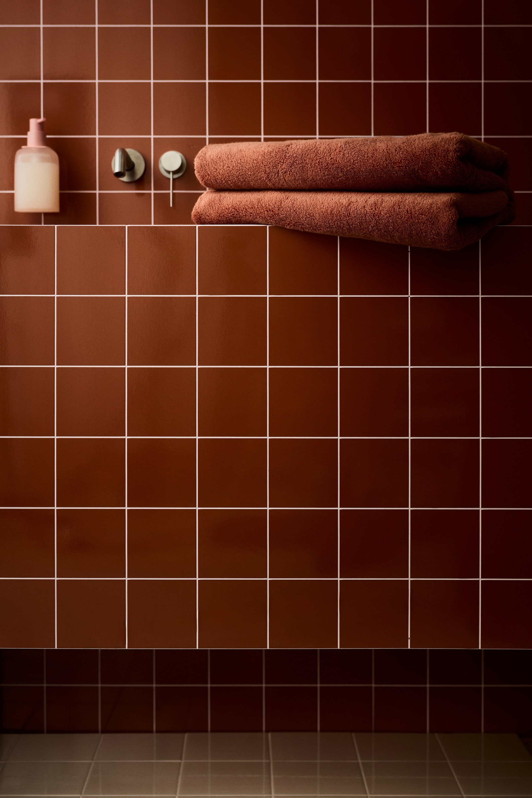 View larger image: Two brown towels are neatly folded and stacked horizontally, displaying a soft, textured surface.