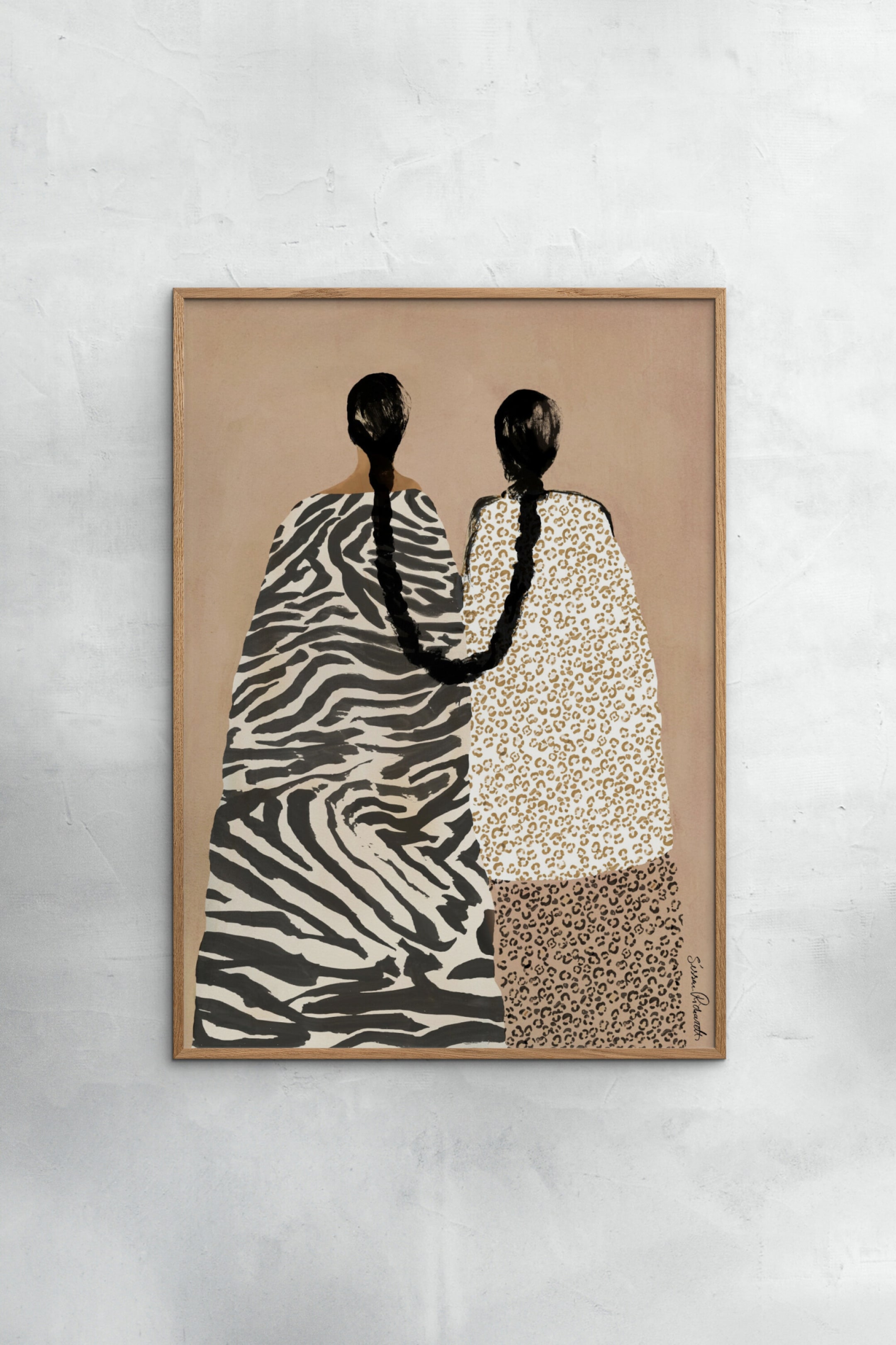 Visualizza immagine più grande: Un'opera d'arte incorniciata raffigura due figure di spalle su uno sfondo marrone chiaro, presentata all'interno di una cornice in legno chiaro. Le figure presentano lunghe trecce nere, con una treccia che si drappeggia sull'altra figura, e indossano abiti con motivi a contrasto di strisce di zebra e macchie di leopardo.