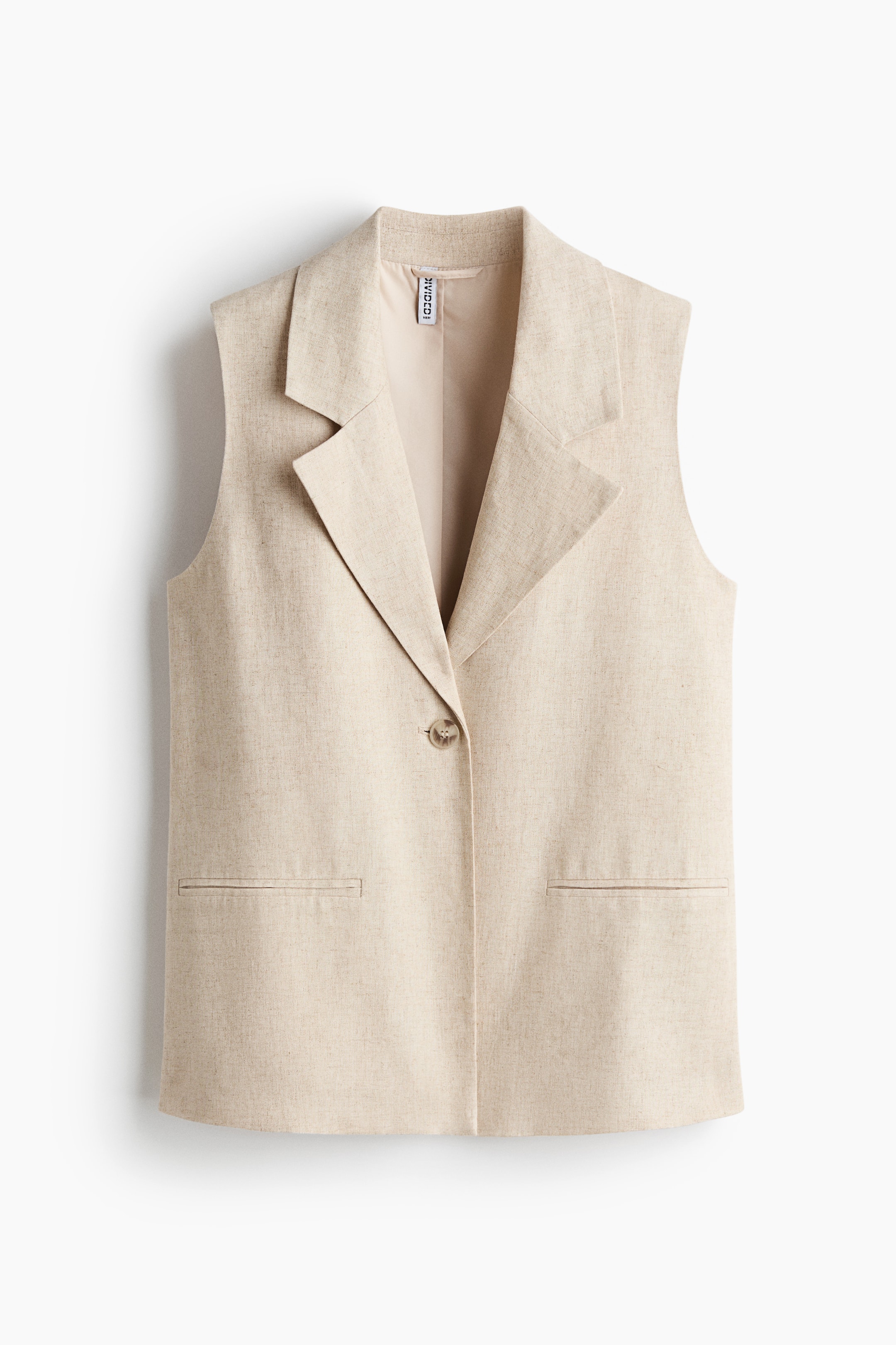 View larger image: A light beige waistcoat in an airy weave is facing front. It is featuring notch lapels, a single-button fastening, and two jetted front pockets, with the lining visible at the neckline.