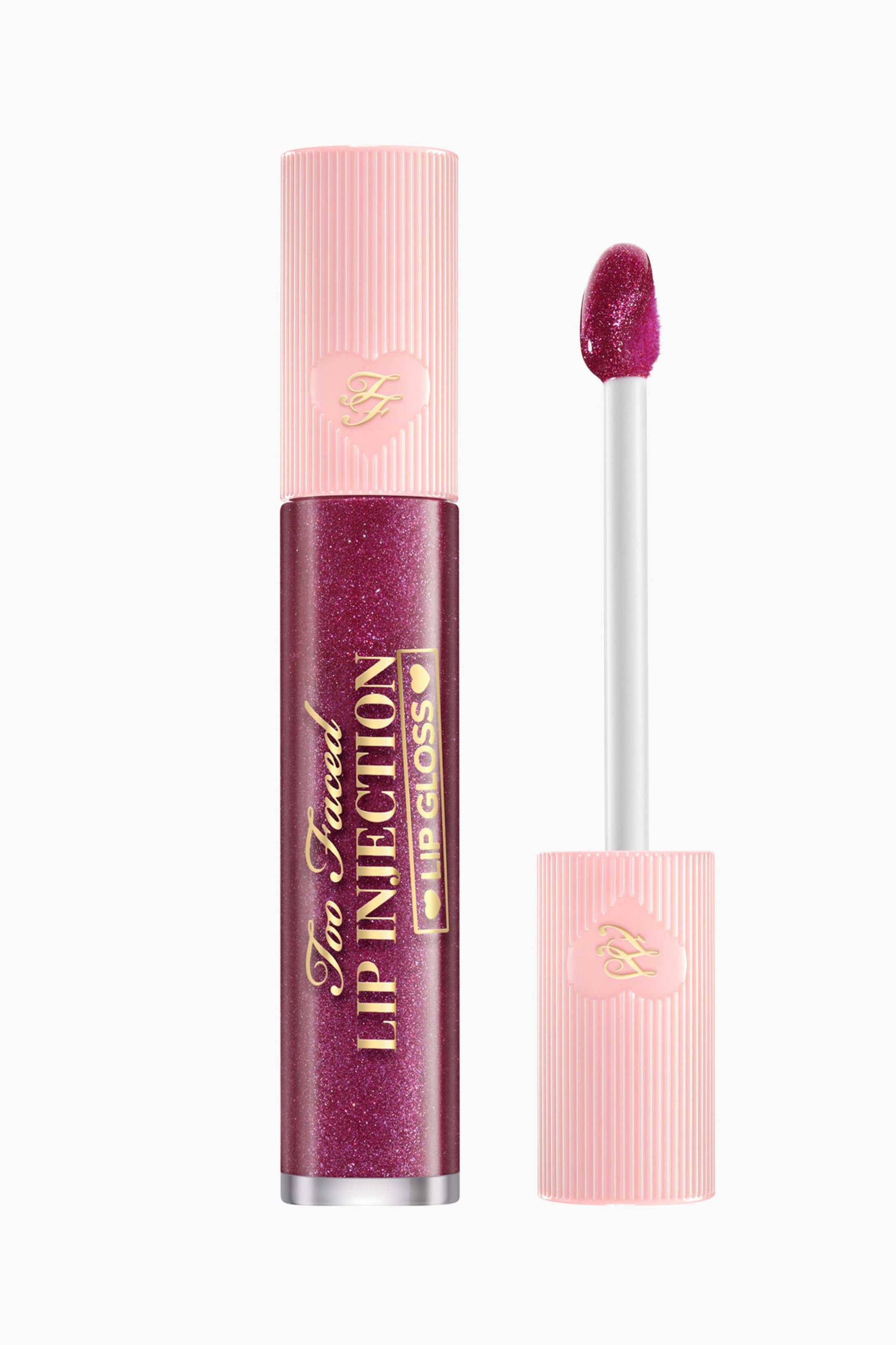 Visa större bild: Ett rör med skimrande bär-lila läppglans, märkt "Too Faced Lip Injection Lip Gloss", står upprätt, med sin ljusrosa ribbade kork prydd med ett hjärtemblem. En doe-foot-applikator, täckt med samma skimrande glans, är placerad bredvid röret.
