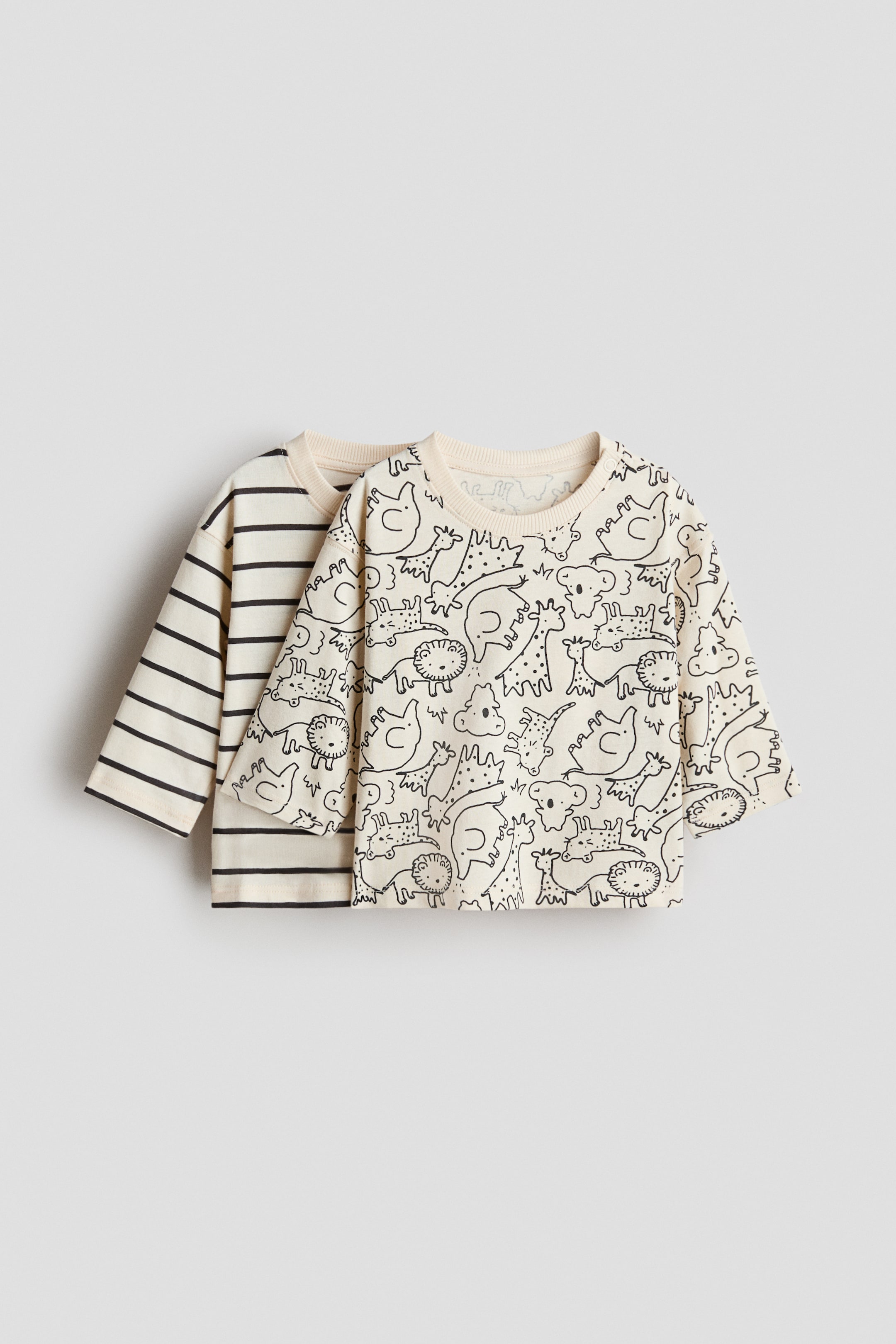 이미지 확대 보기: 2팩 프린트 티셔츠가 전면에 보이며, 한 티셔츠는 오프 화이트 배경에 전체 블랙 아웃라인 동물 프린트를 특징으로 하고, 다른 티셔츠는 오프 화이트 배경에 블랙 가로 줄무늬를 보여줍니다. 각 티셔츠는 긴 소매, 리브드 커프스, 리브드 크루넥을 보여줍니다.