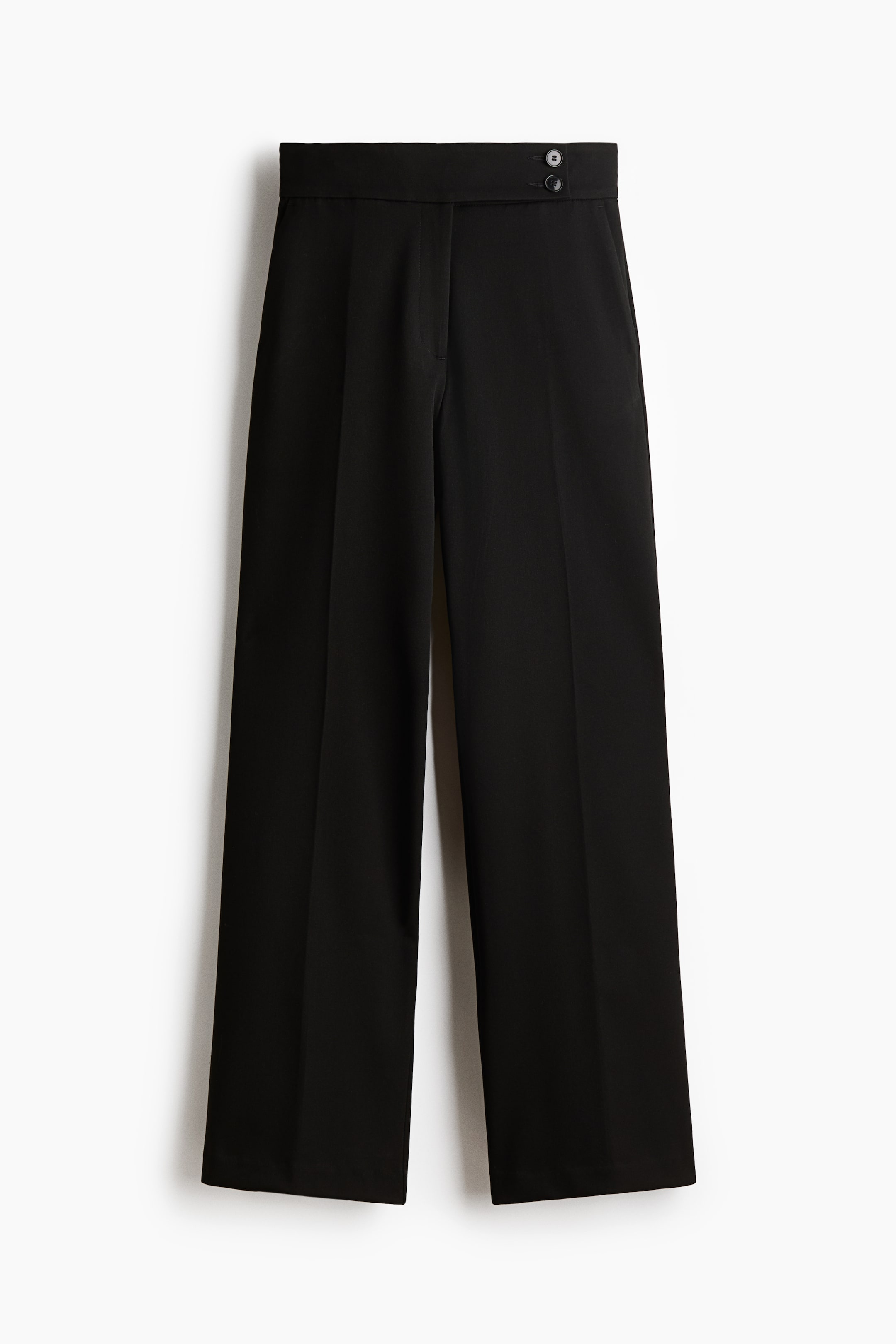 View larger image: Fitted black trousers are presenting a front view, featuring a high waist with an extended waistband and two visible buttons on the right side, and a zip fly. The trousers are designed with bootcut legs and creases running down the front.