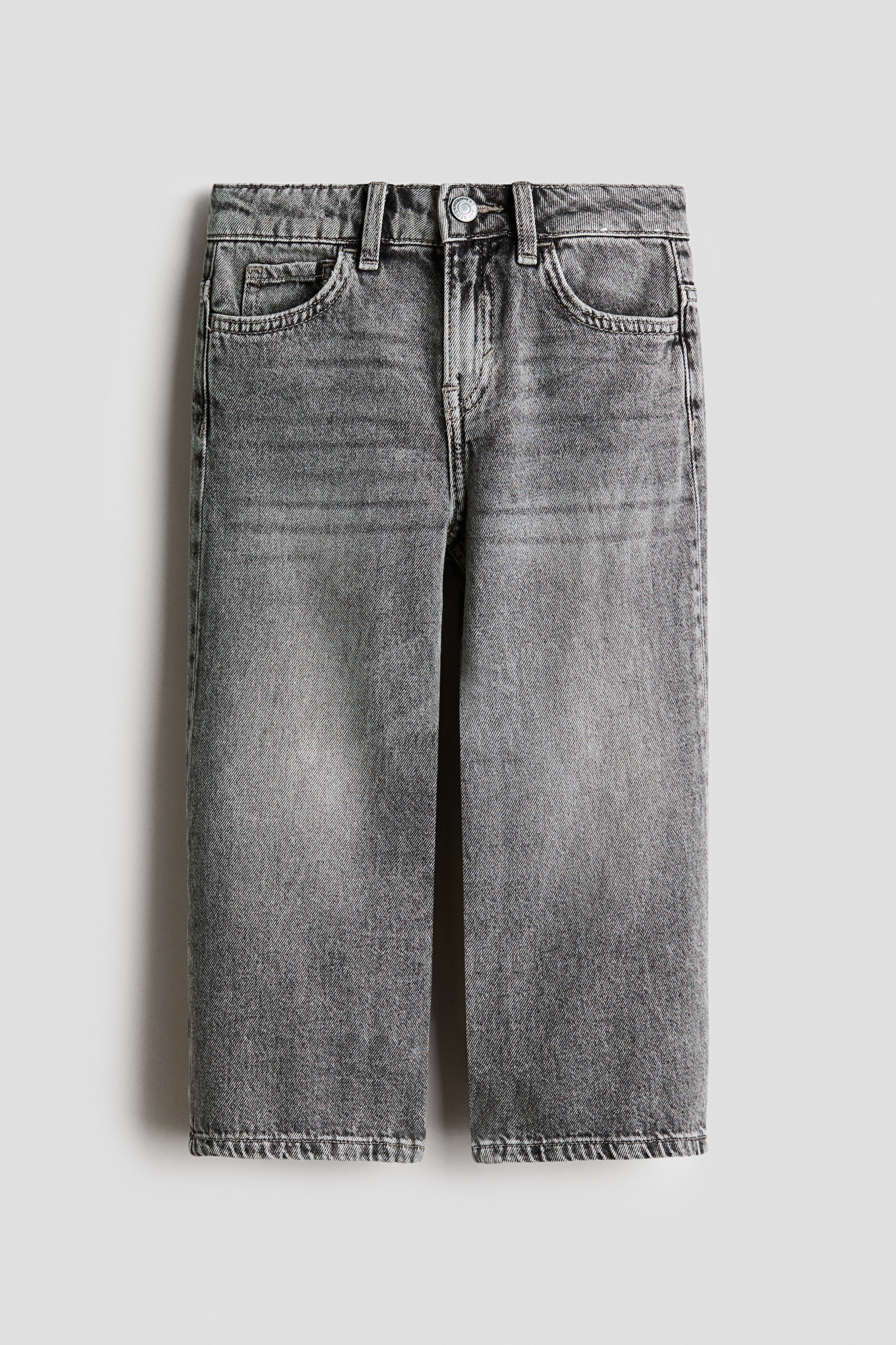 View larger image: Grey jeans are presented front-facing, featuring a loose fit and a faded grey wash. They display a waistband with belt loops, two front pockets, a coin pocket, and a metal button fastening at the waist.