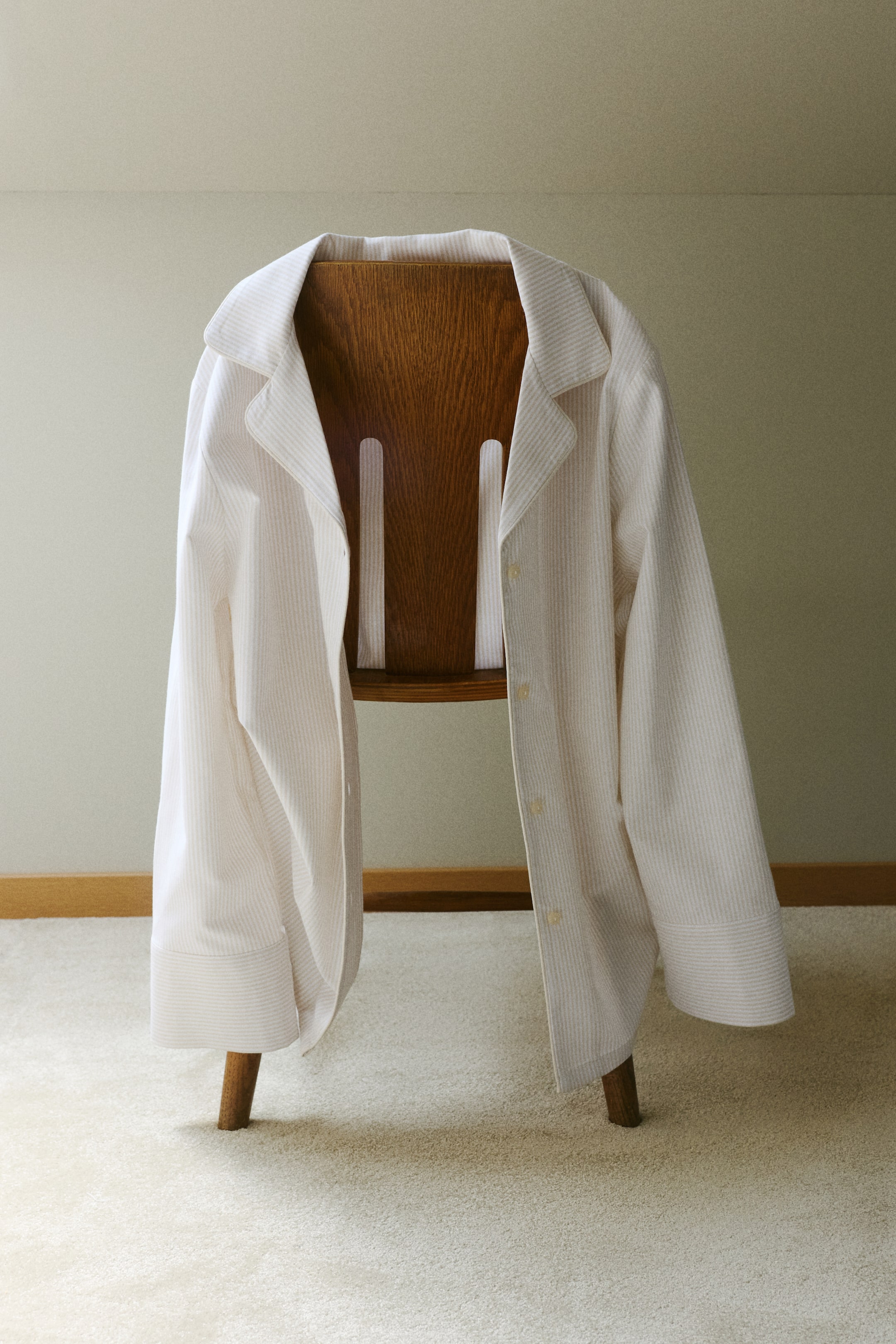 Grösseres Bild ansehen: Ein Pyjama-Hemd aus gestreiftem Oxford-Baumwollstoff wird mit der Vorderseite nach vorne drapiert und verfügt über einen abgerundeten Resort-Kragen, Knöpfe entlang der Vorderseite, lange Ärmel mit Manschetten und Paspeln entlang des Kragens und der Knopfleiste.