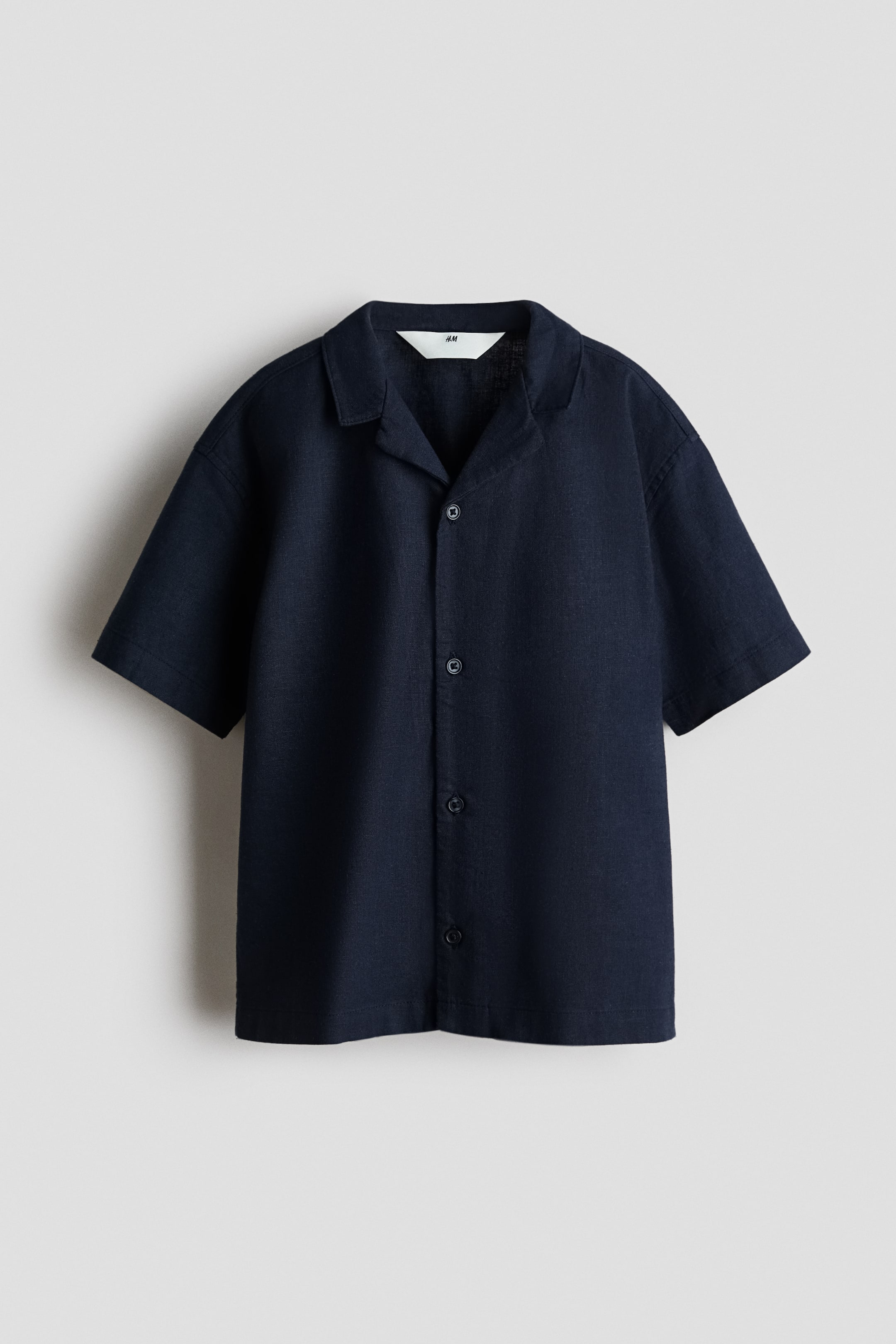 View larger image: A dark blue short-sleeved shirt shown from the front. It features an airy weave, a resort collar, buttons running down the front, and dropped shoulders.