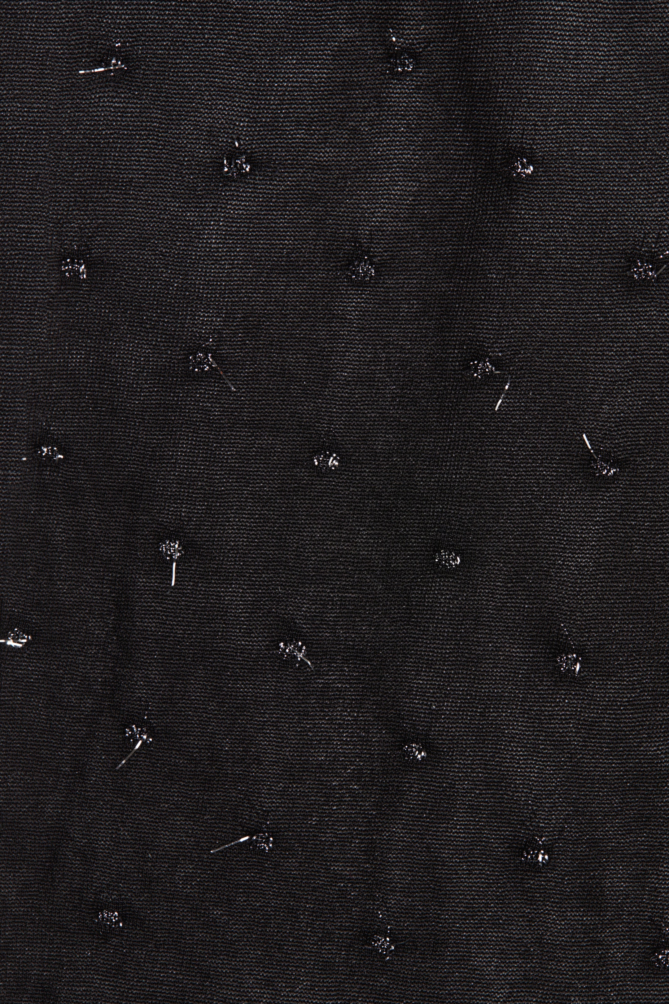 Prikaži veću sliku: Crna, fino tkana tkanina ima rasute, nepravilno oblikovane srebrne metalne elemente po svojoj površini.