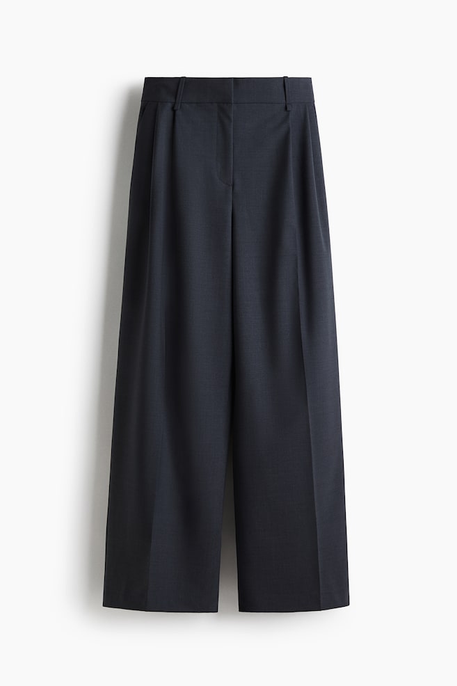 Dark charcoal gray wide-leg pants are shown from the front, featuring a flat waistband with belt loops, single front pleats, and prominent center creases on each leg, ending at a cropped length. - 1