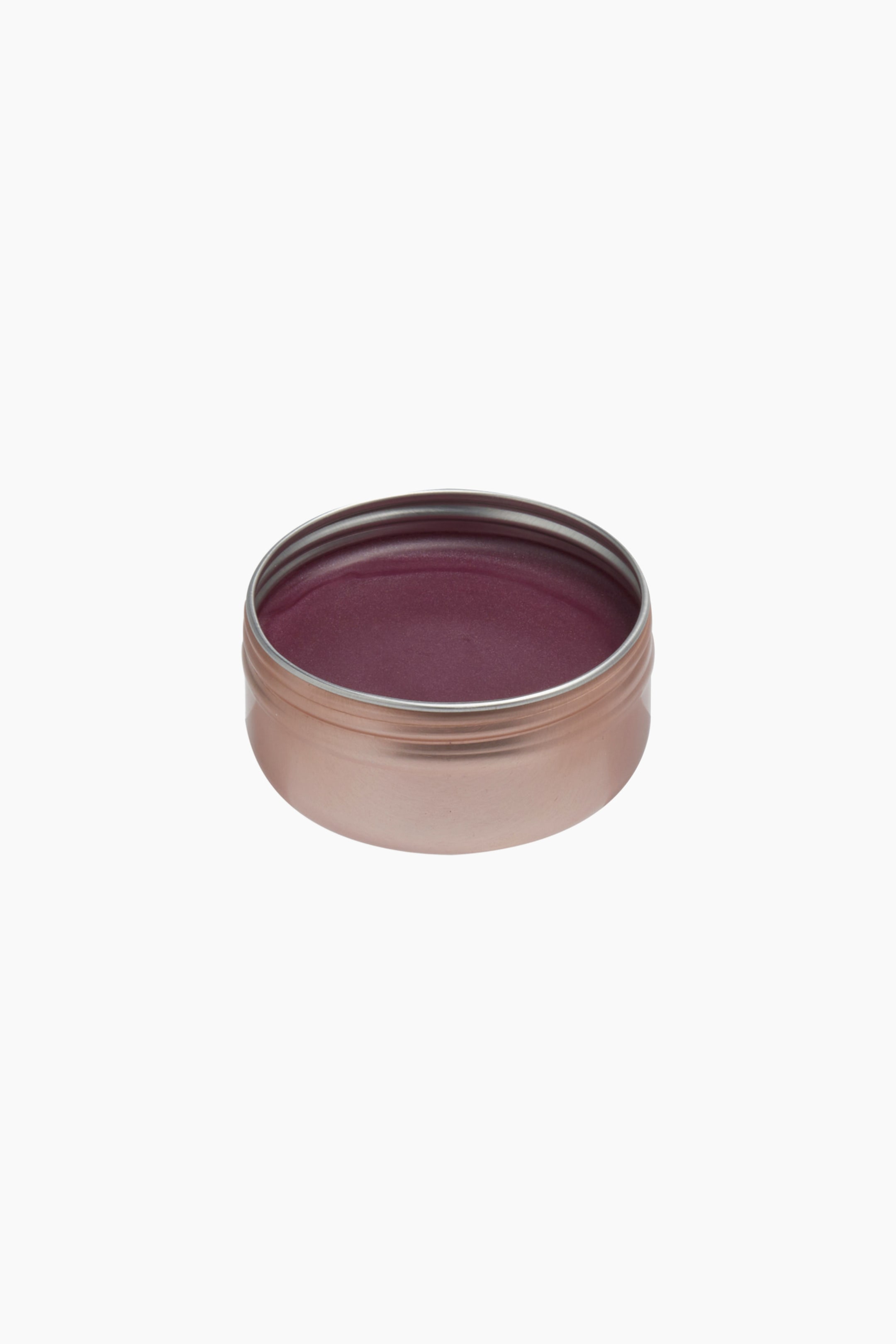 Größeres Bild ansehen: Eine runde, roségoldfarbene Metalldose zeigt einen tief pflaumenfarbenen Creme-Balm mit glatter, leicht glänzender Oberfläche. Der offene Behälter liegt in leichtem Winkel und präsentiert den satten Beerenton im Inneren.