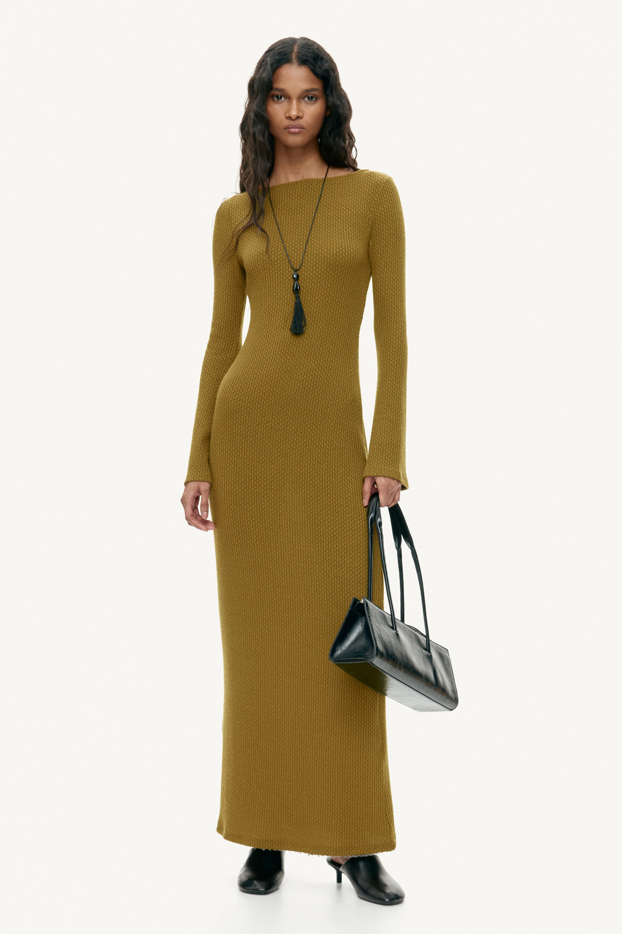 Ampliar la imagen: Un vestido maxi de punto texturizado en verde oliva presenta un escote barco y mangas largas, mostrando una silueta ajustada que se extiende hasta los tobillos.