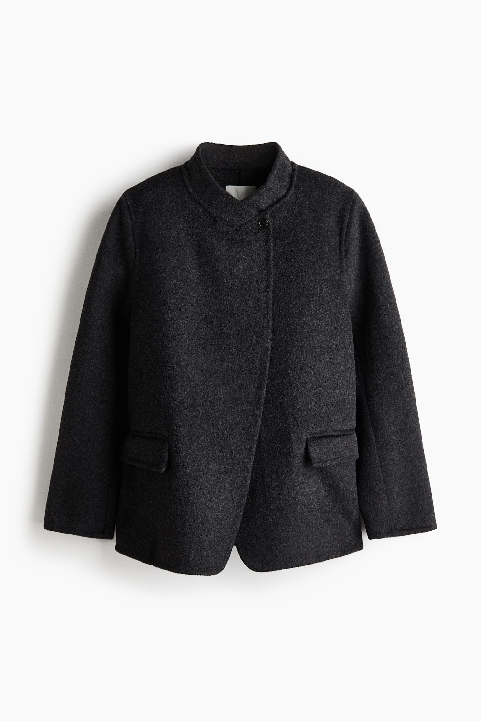 En mørkegrå blazer i filtet uldblanding set forfra, med ståkrave, markerede skuldre og en let forskudt lukning foran med en enkelt synlig knap ved halsudskæringen. Blazeren har også lange ærmer og to lodrette forlommer med klapper. - 1