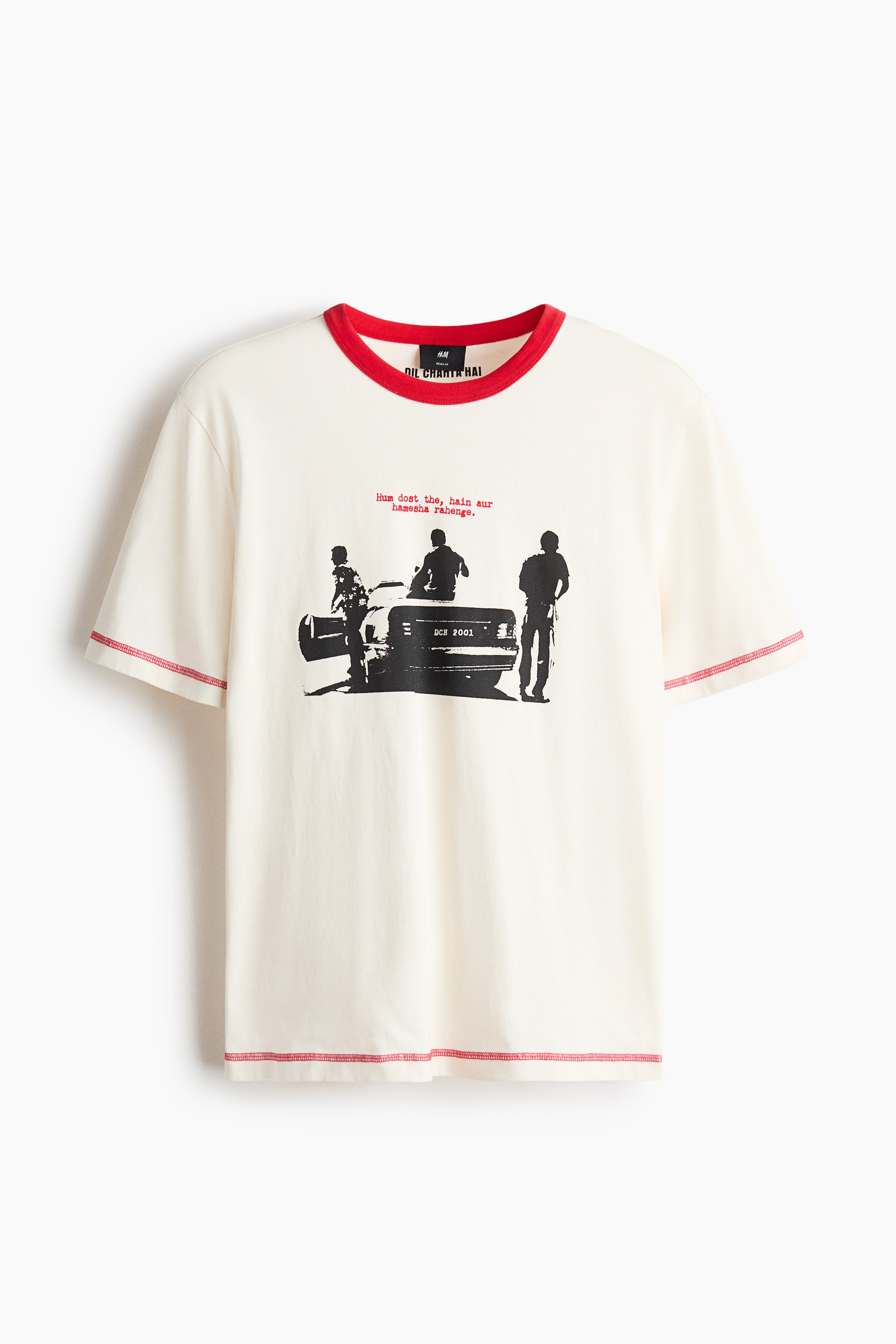 View larger image: A cream-coloured T-shirt is shown from the front, featuring a red ribbed round neck and short sleeves. It showcases a black graphic print of three figures and a car on the chest, along with red and black text details, and red visible stitching outlining the shoulders, sleeve hems, and bottom hem.