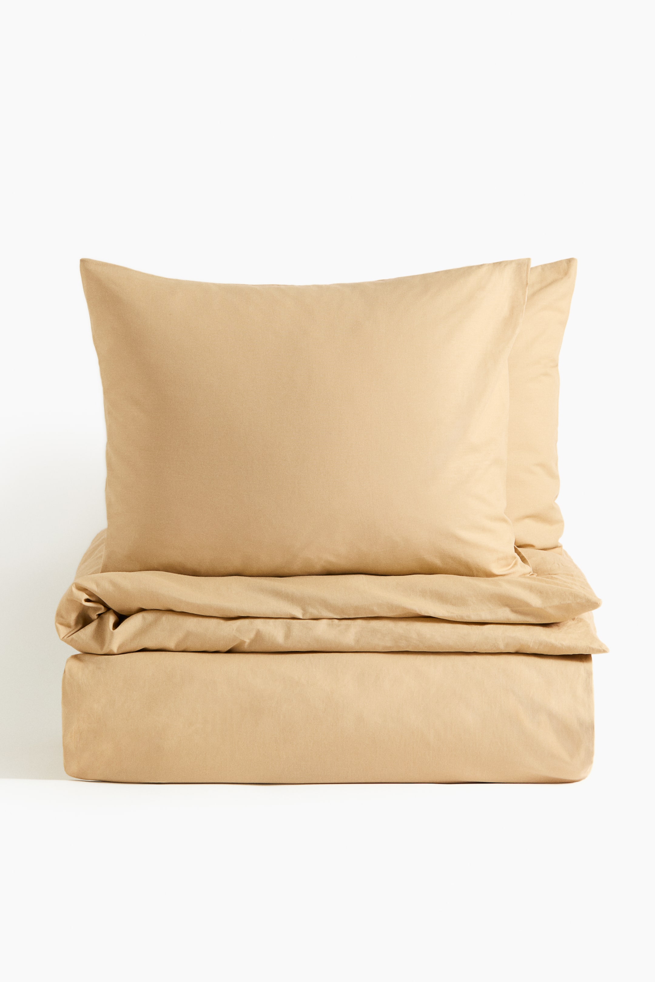 View larger image: A double duvet cover set in light brown, finely woven cotton is shown from the front, featuring a neatly folded duvet cover with two matching pillowcases stacked on top.