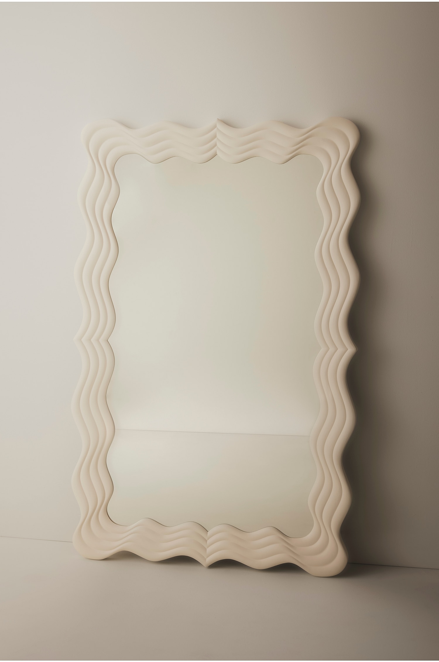 Un miroir rectangulaire est posÃ© lÃ©gÃ¨rement de biais, avec un cadre Ã©pais Ã  finition beige mate et un design ondulÃ© superposÃ©. Les bordures sculptÃ©es crÃ©ent une texture ondulÃ©e autour du verre rÃ©flÃ©chissant clair.