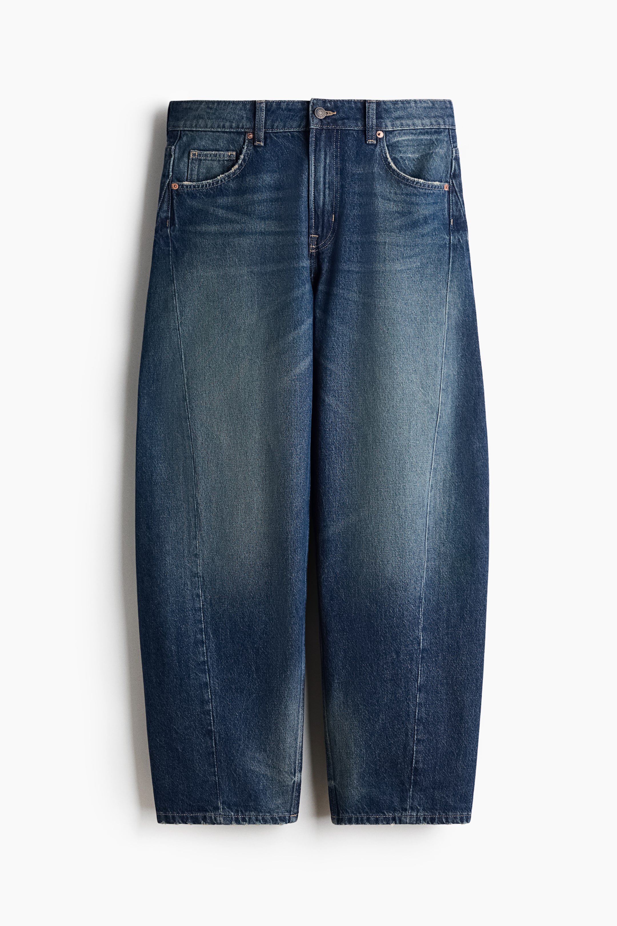 Büyük resmi görüntüle: Koyu mavi denim jeanler, her bir bacak boyunca uzanan belirgin dikey dikişlerle tanımlanan geniş, barrel-leg siluete sahiptir. Soluklaştırılmış yıkama efekti, beş cepli tasarım ve bel kısmında düğme ve fermuar kapama detaylarıyla sunulmaktadır.