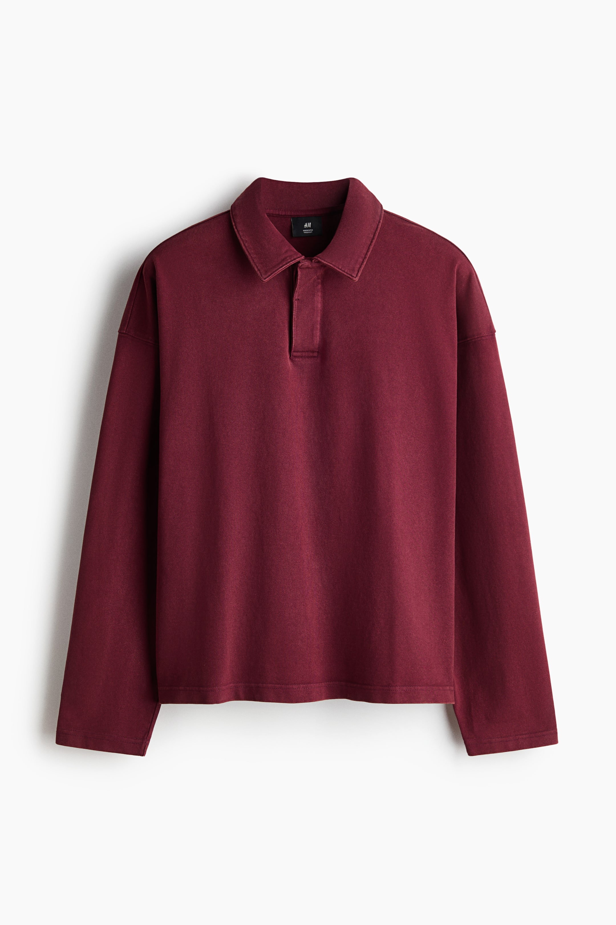 View larger image: A long-sleeved burgundy polo shirt with a slightly faded appearance is featured here. It has a polo collar, a short placket, a relaxed fit, and a straight hem.
