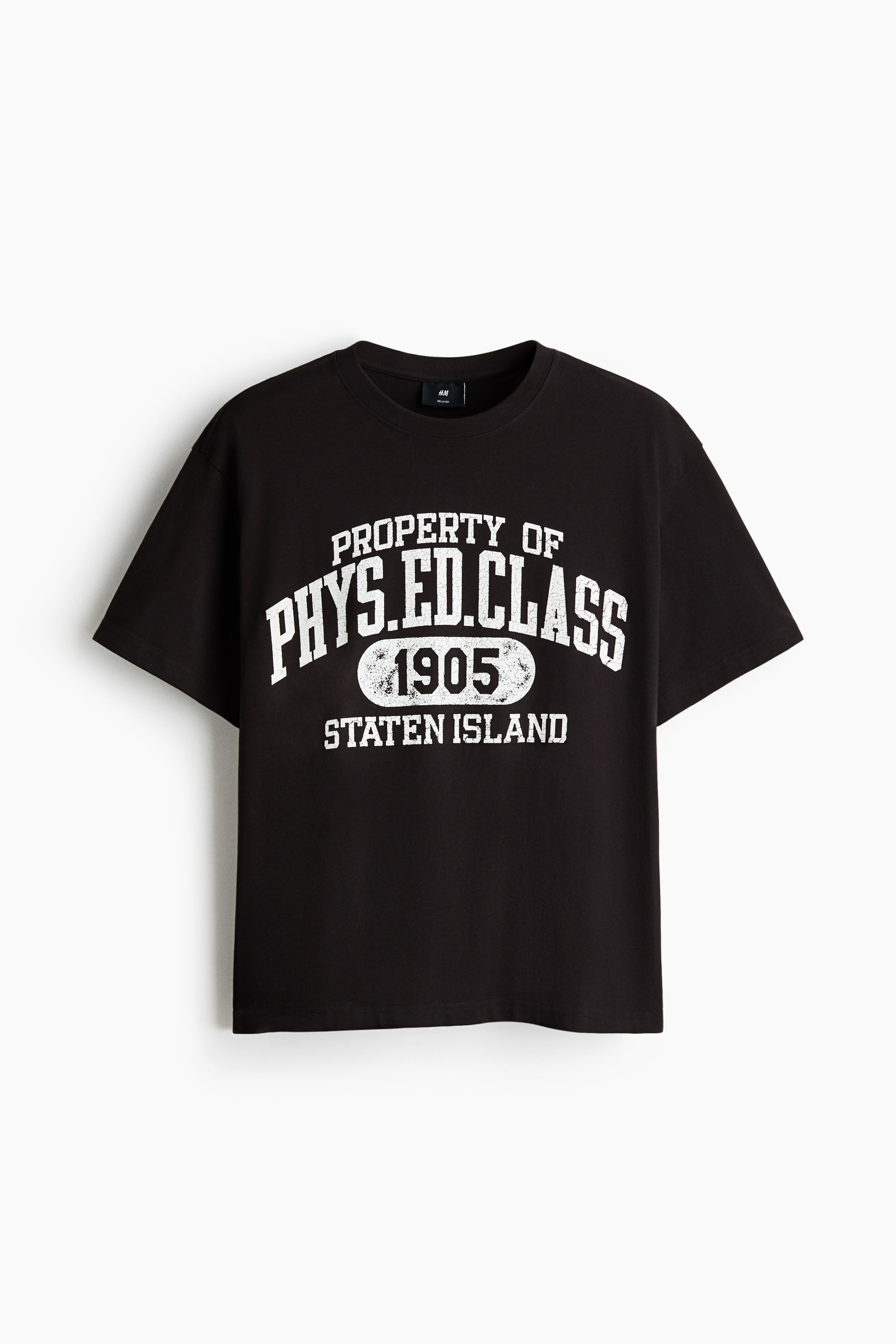 Agrandir l'image: Un T-shirt noir présente un motif imprimé blanc vieilli sur le devant, portant l'inscription « PROPERTY OF PHYS.ED.CLASS 1905 STATEN ISLAND ». Il est conçu avec un col rond bordé de côtes, des épaules tombantes et un ourlet droit, offrant une coupe ample.
