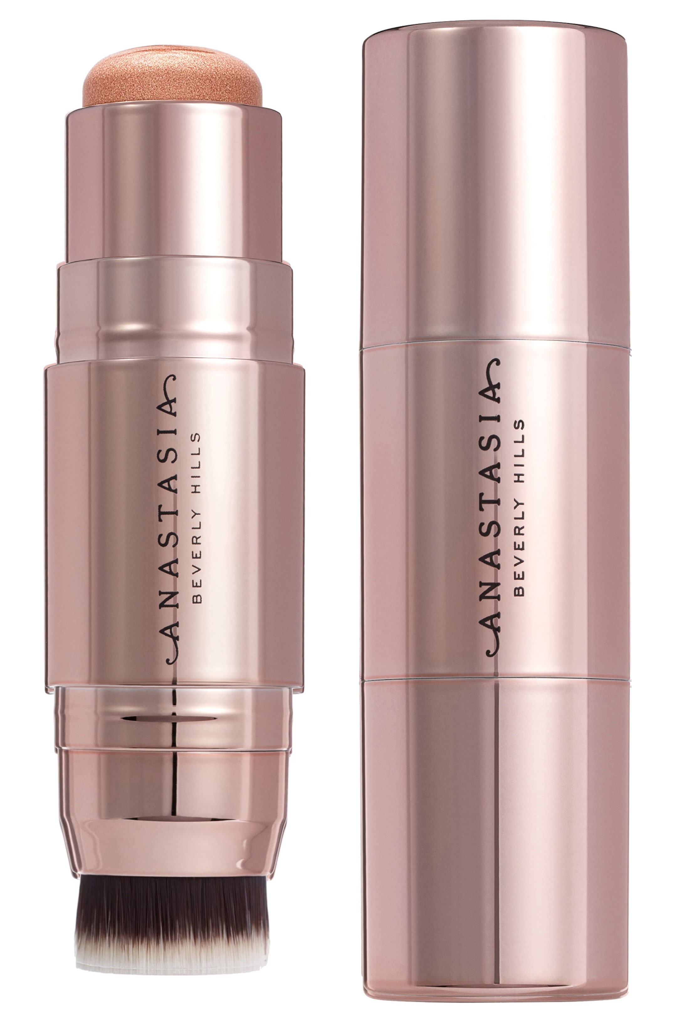 Se større billede: En roseguld kosmetikstift står oprejst, med et forlænget, skinnende, let kobberfarvet makeup-produkt øverst og en blending børste nederst. En identisk stift, der ser lukket ud, er placeret oprejst ved siden af, begge med "ANASTASIA BEVERLY HILLS" mærkenavnet vist lodret.