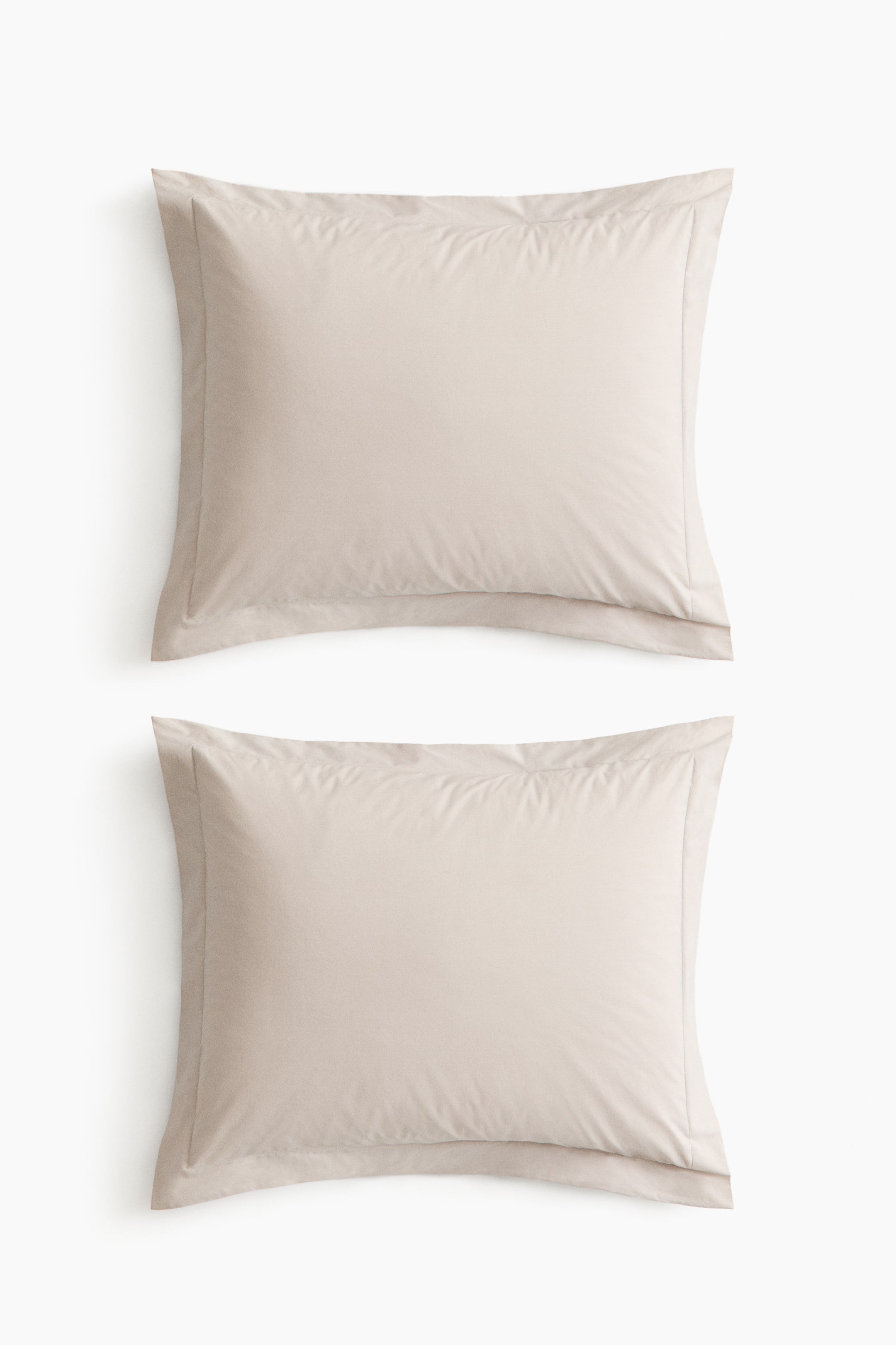 View larger image: Two light beige, rectangular pillowcases are lying flat, facing front, each adorned with a flanged border.