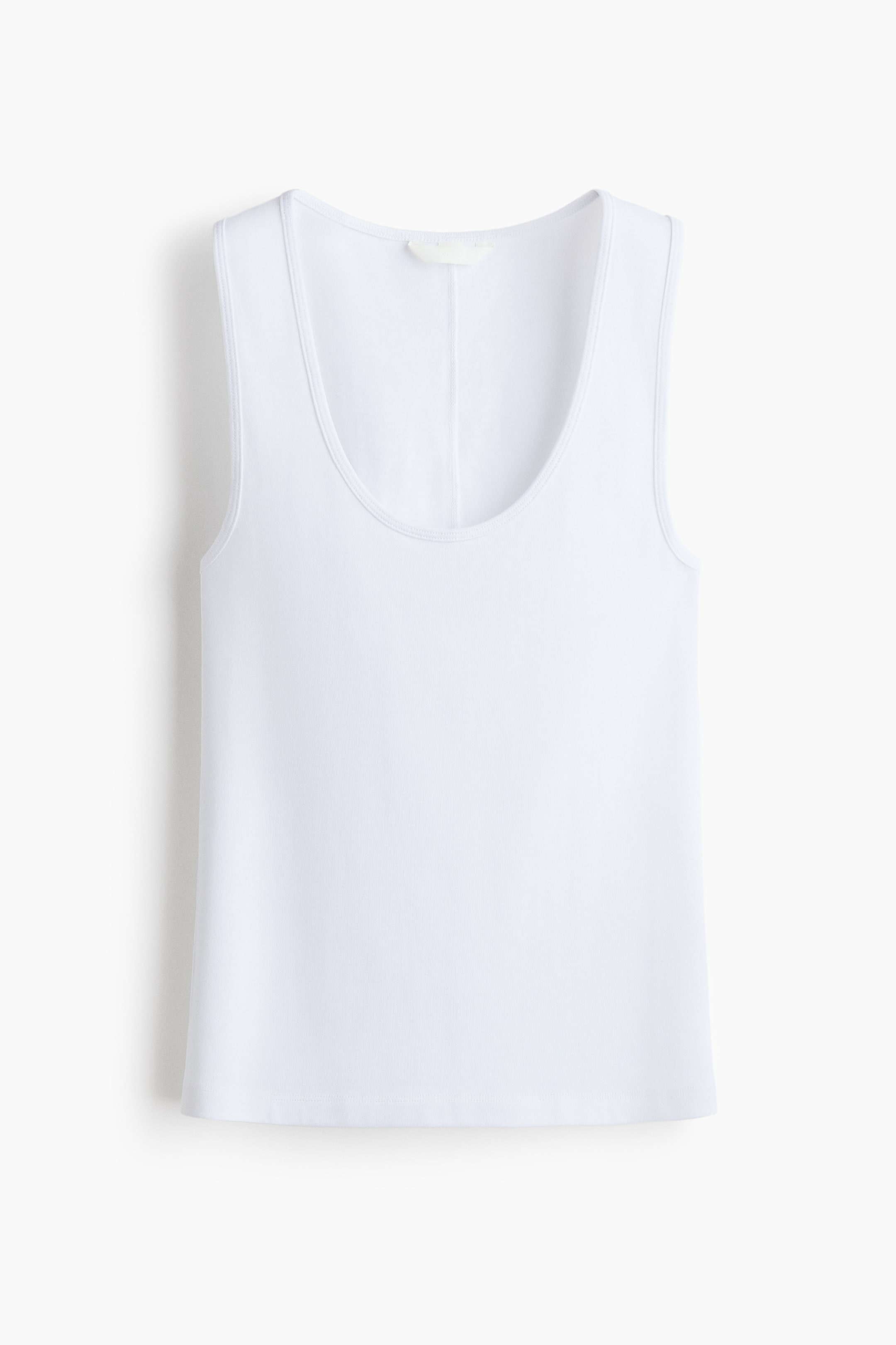 Xem ảnh lớn hơn: Áo tank top màu trắng có cổ tròn và thiết kế không tay, được trình bày từ phía trước. Đường chỉ may rõ ràng viền quanh cổ áo, lỗ tay và gấu áo thẳng, trong khi nhãn màu sáng và đường may dọc xuất hiện ở phía sau cổ áo.