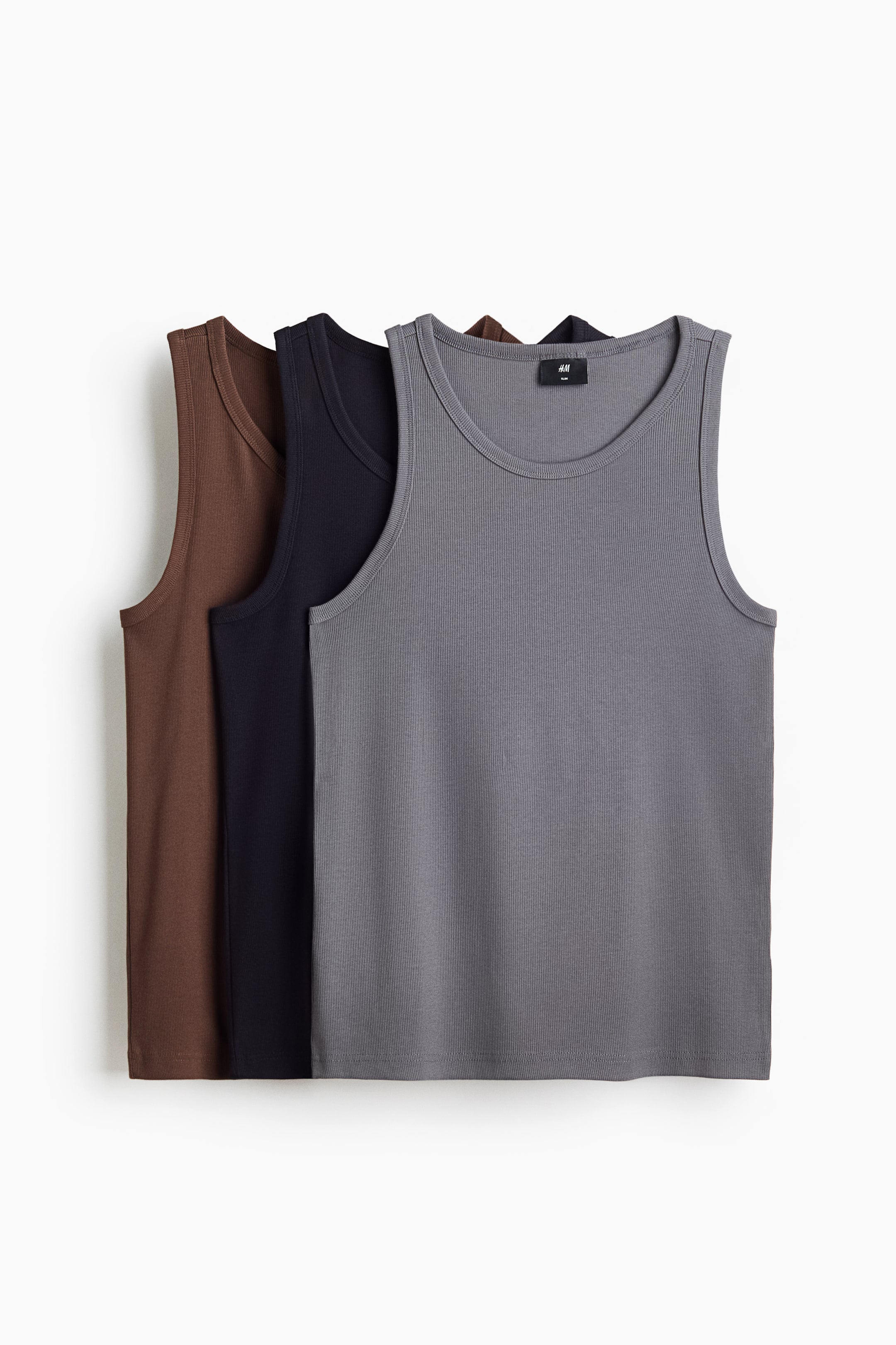 Agrandir l'image: Trois débardeurs sont présentés de face, superposés en marron, noir et gris. Chaque débardeur présente une texture en jersey côtelé, un col rond et un ourlet droit, conçus avec une coupe ajustée.