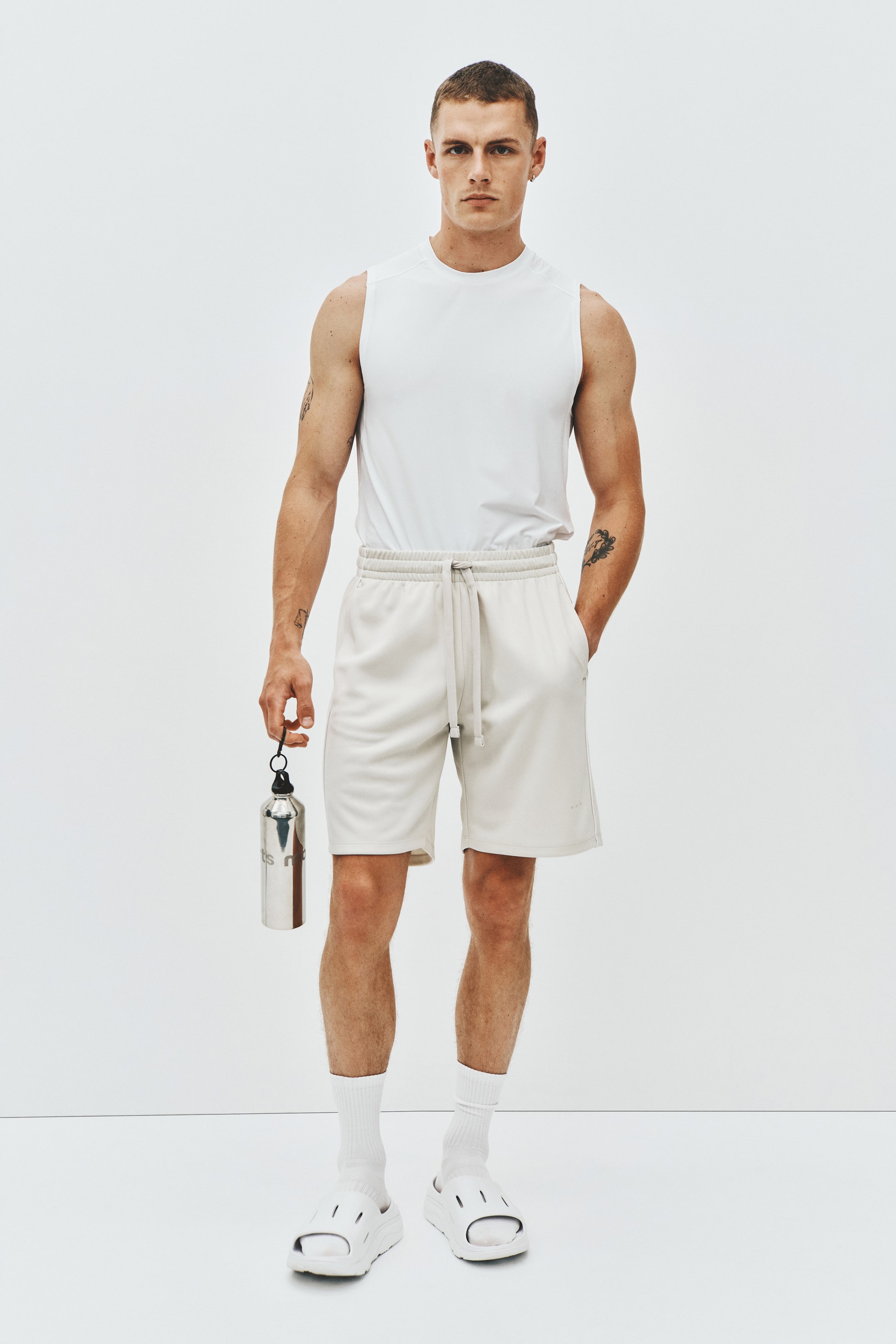 View larger image: A white sleeveless top is showcased from the front, featuring a crew neck and visible shoulder seams.