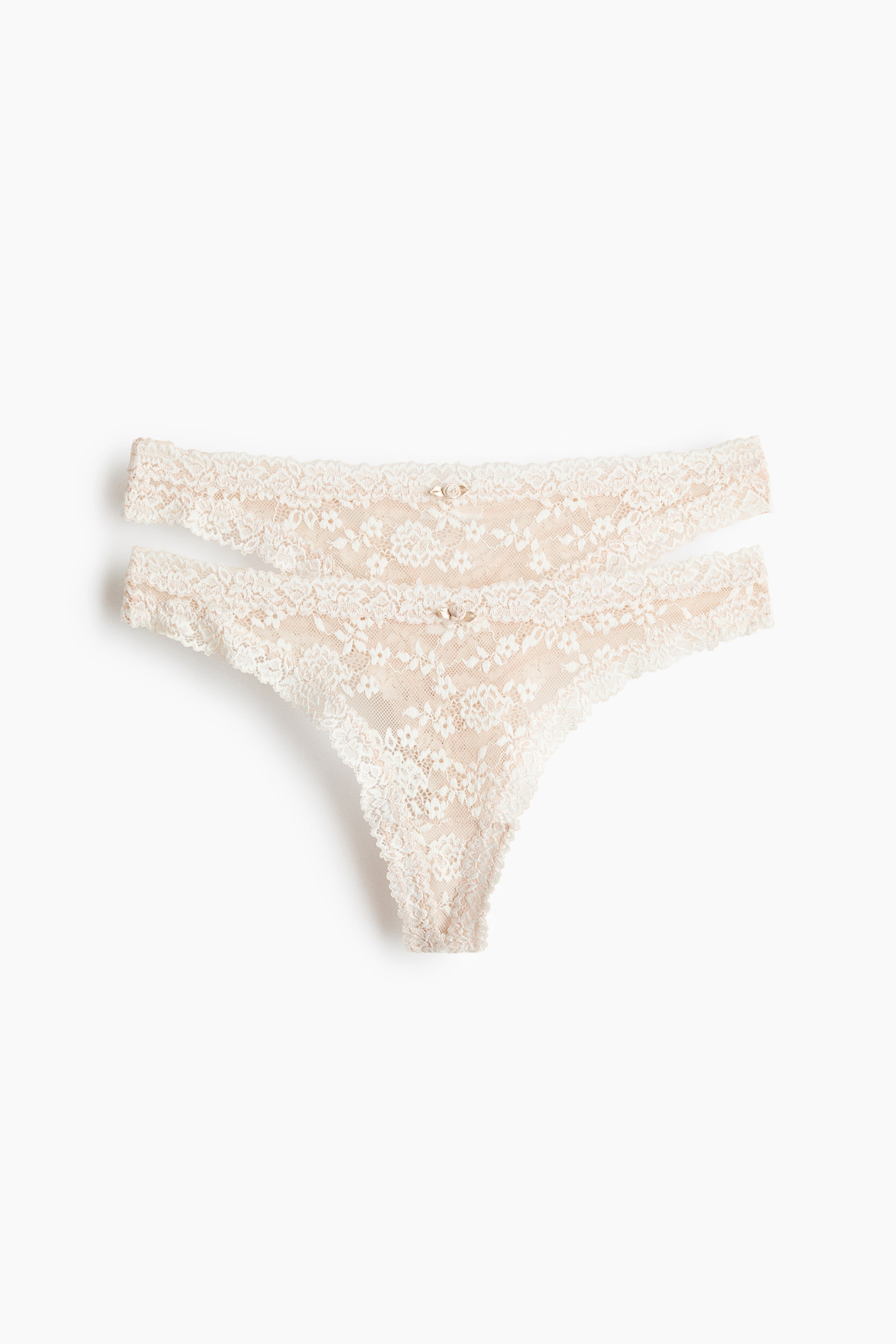 View larger image: Two light beige lace thong briefs are showcased at the front, each boasting a low-rise waist and adorned with a petite bow at the centre front.