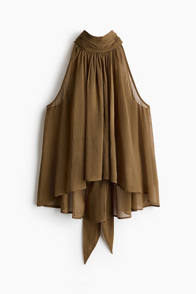 The brown sleeveless top comes with a ruched high neck and a flowing, crinkled fabric. It highlights an asymmetrical high-low hem with layered ruffles and a tie detail at the lower back. - 1